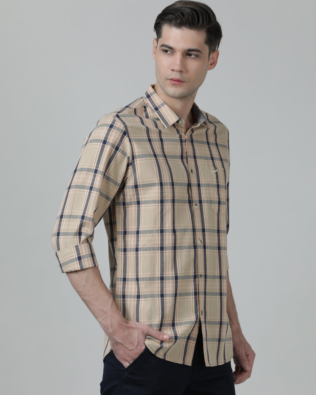 Man wearing a beige beige checked full sleeve 100% cotton shirt with casual styling on a gray background