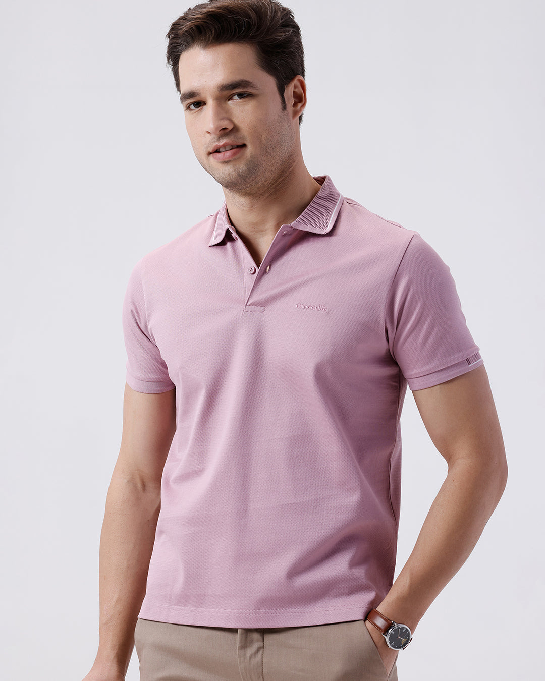 Man wearing a red mercerized subtle textured polo t shirt with casual styling on a gray background