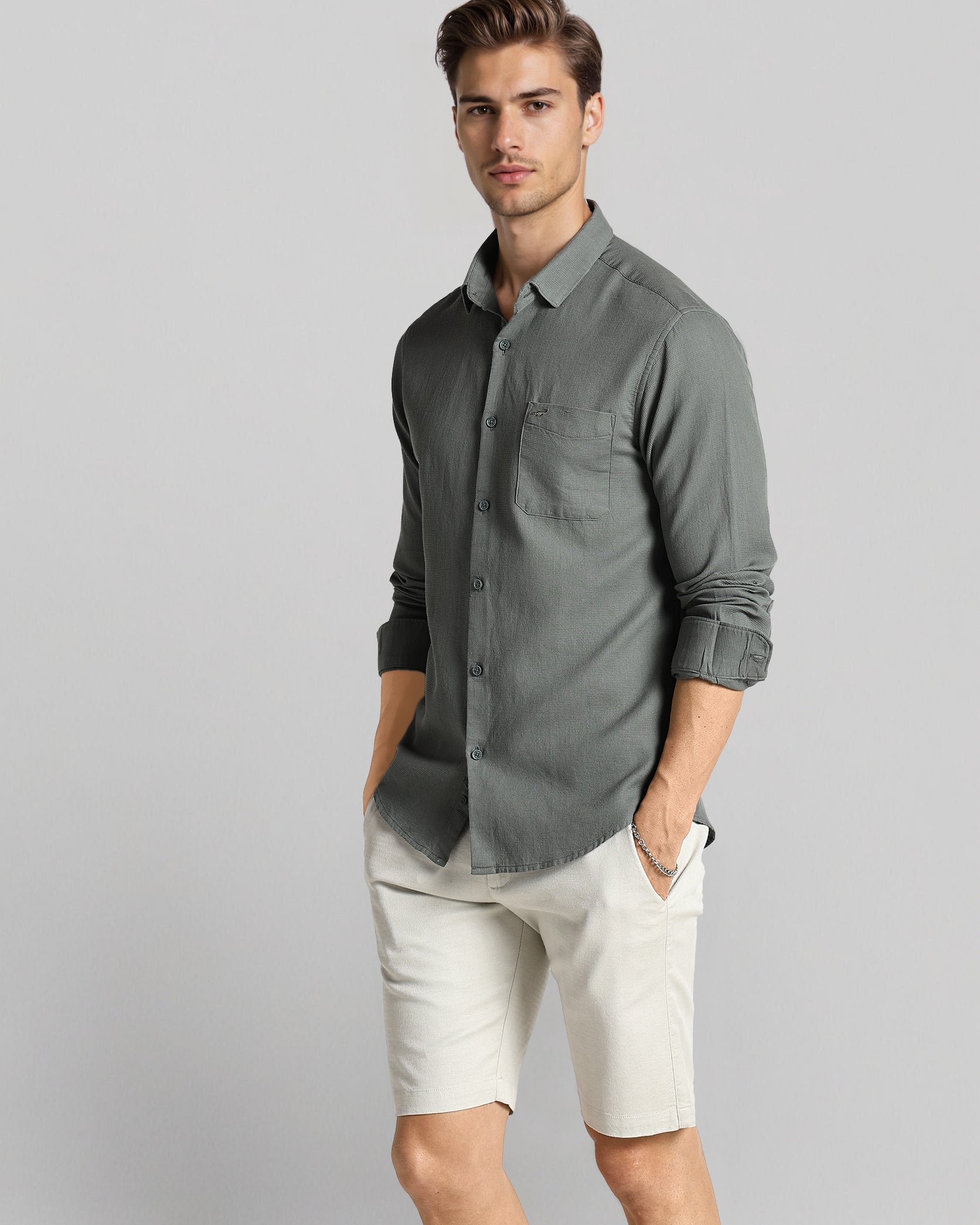 Man wearing a gray shirt and white shorts on a gray background