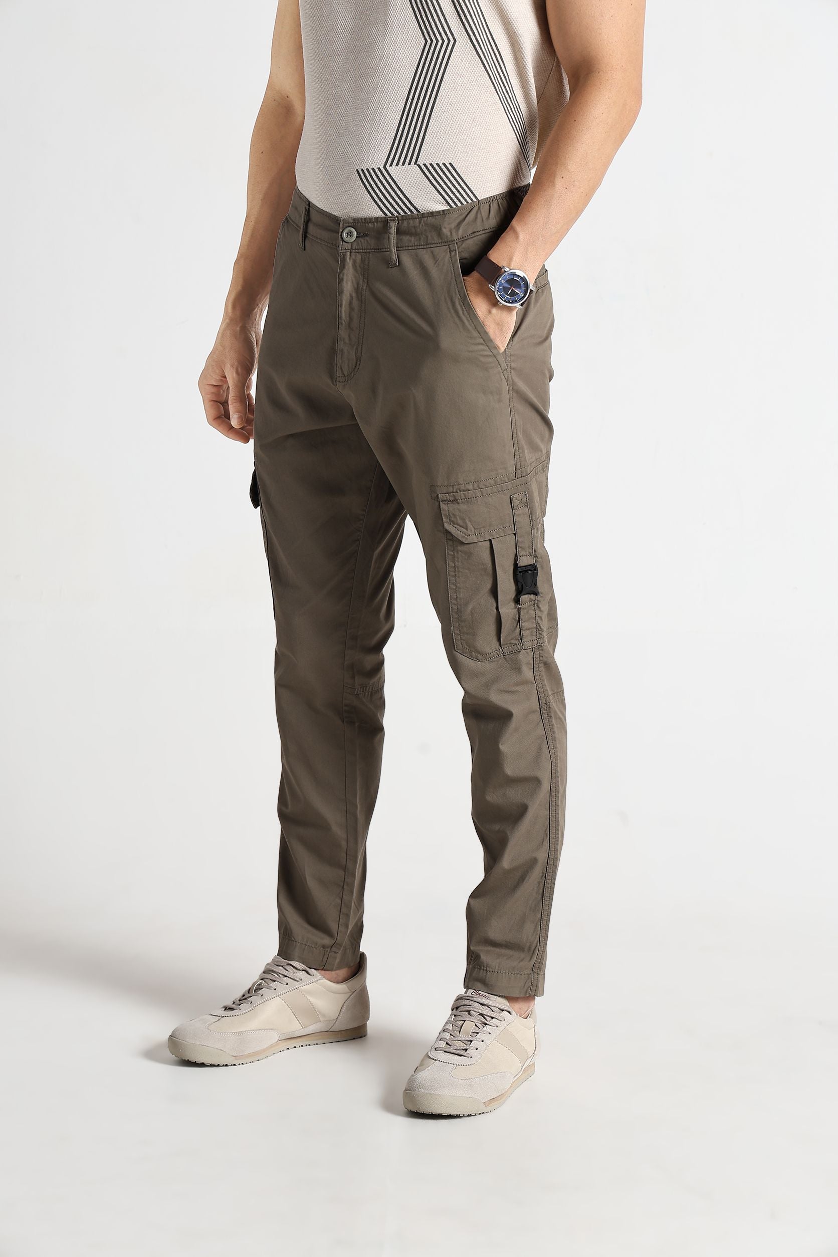 Person wearing gray cargo pants on a white background