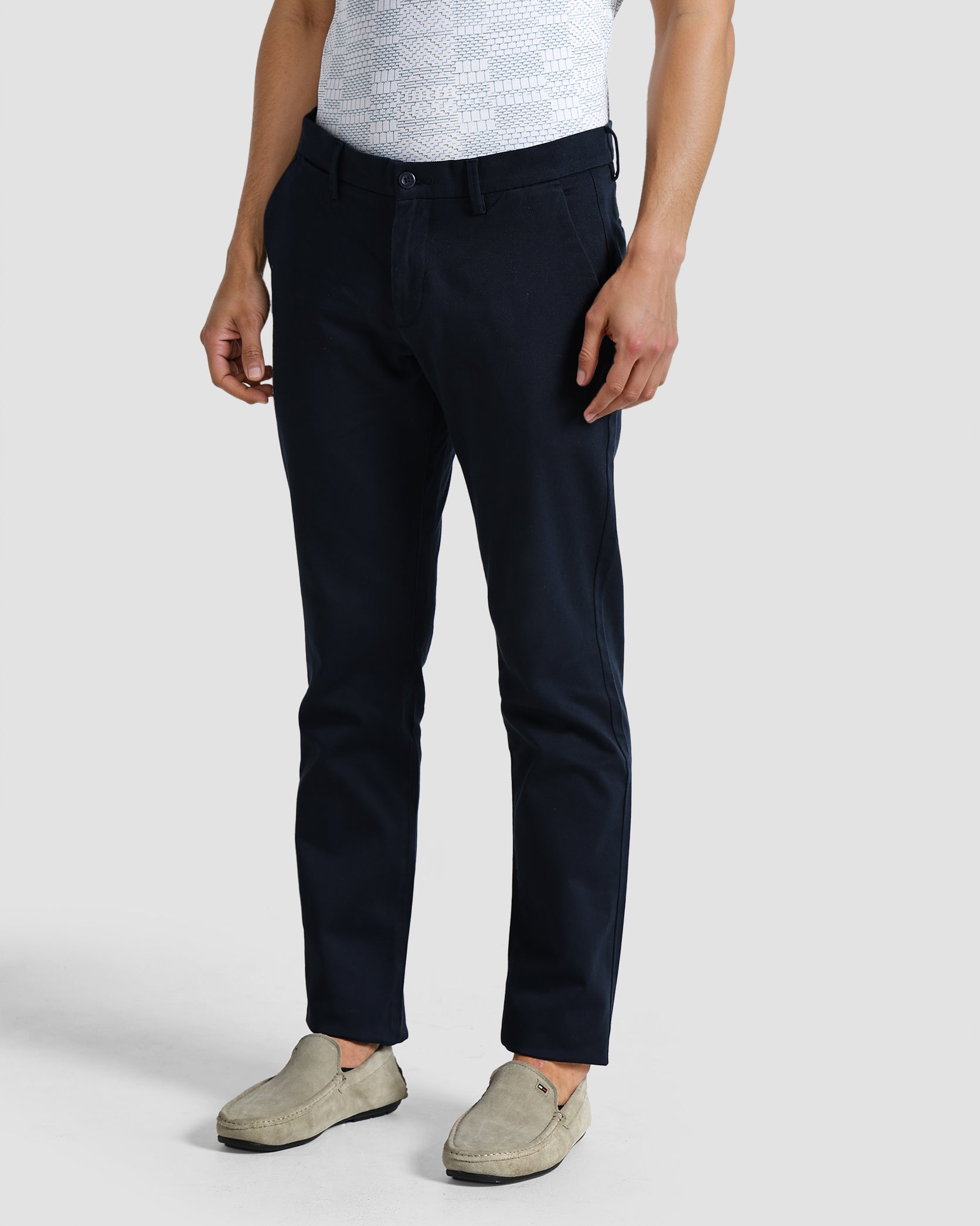 Person wearing navy pants and a light gray shirt on a white background