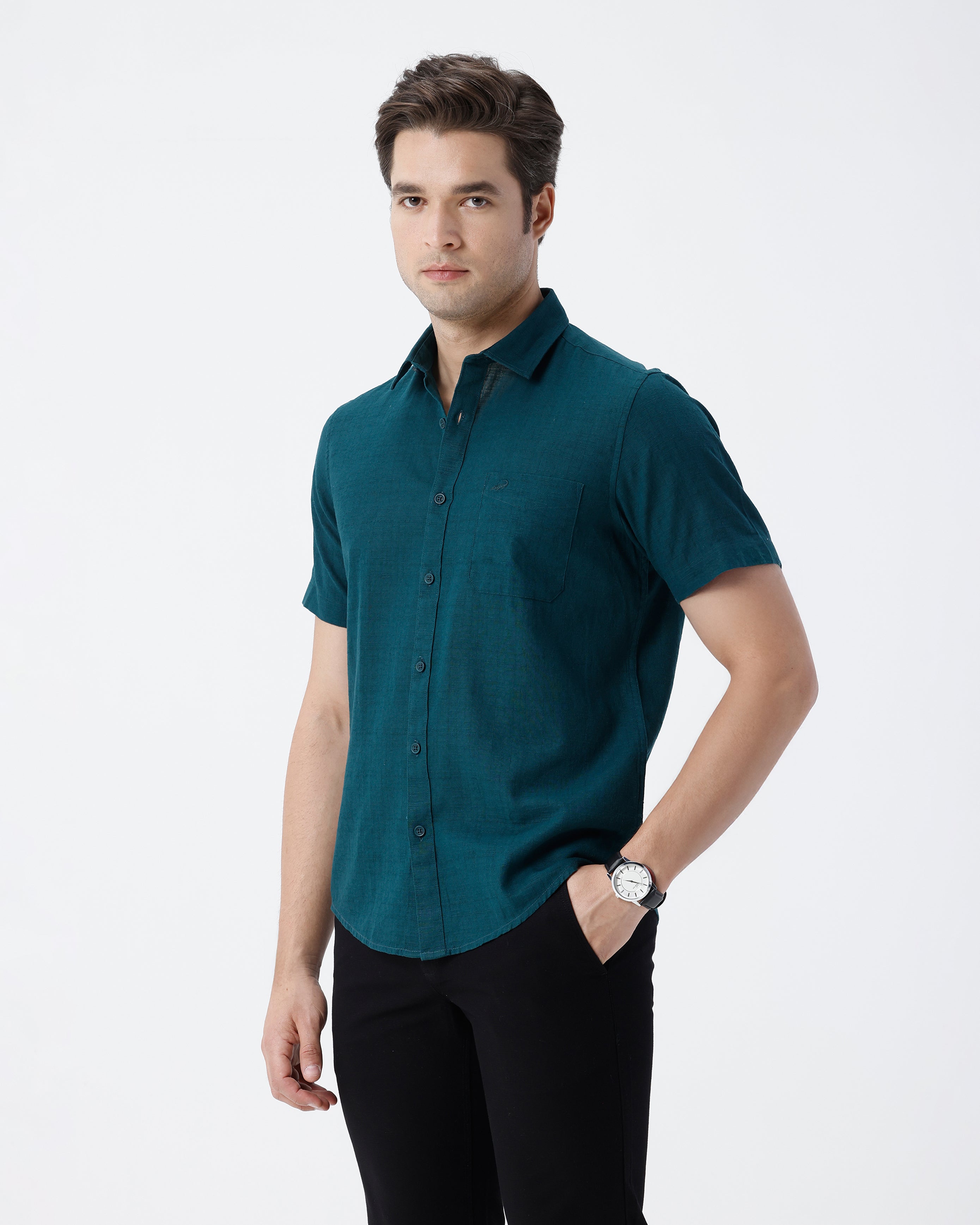 Man wearing a green pure cotton textured shirt green with casual styling on a gray background