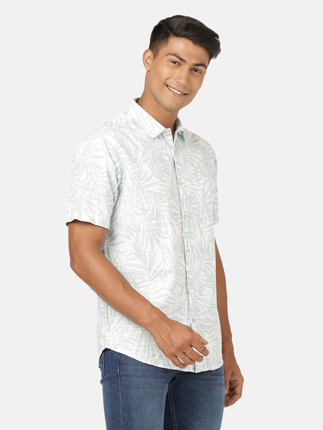 Man wearing a green sea green printed half sleeve 100% cotton shirt on a light gray background