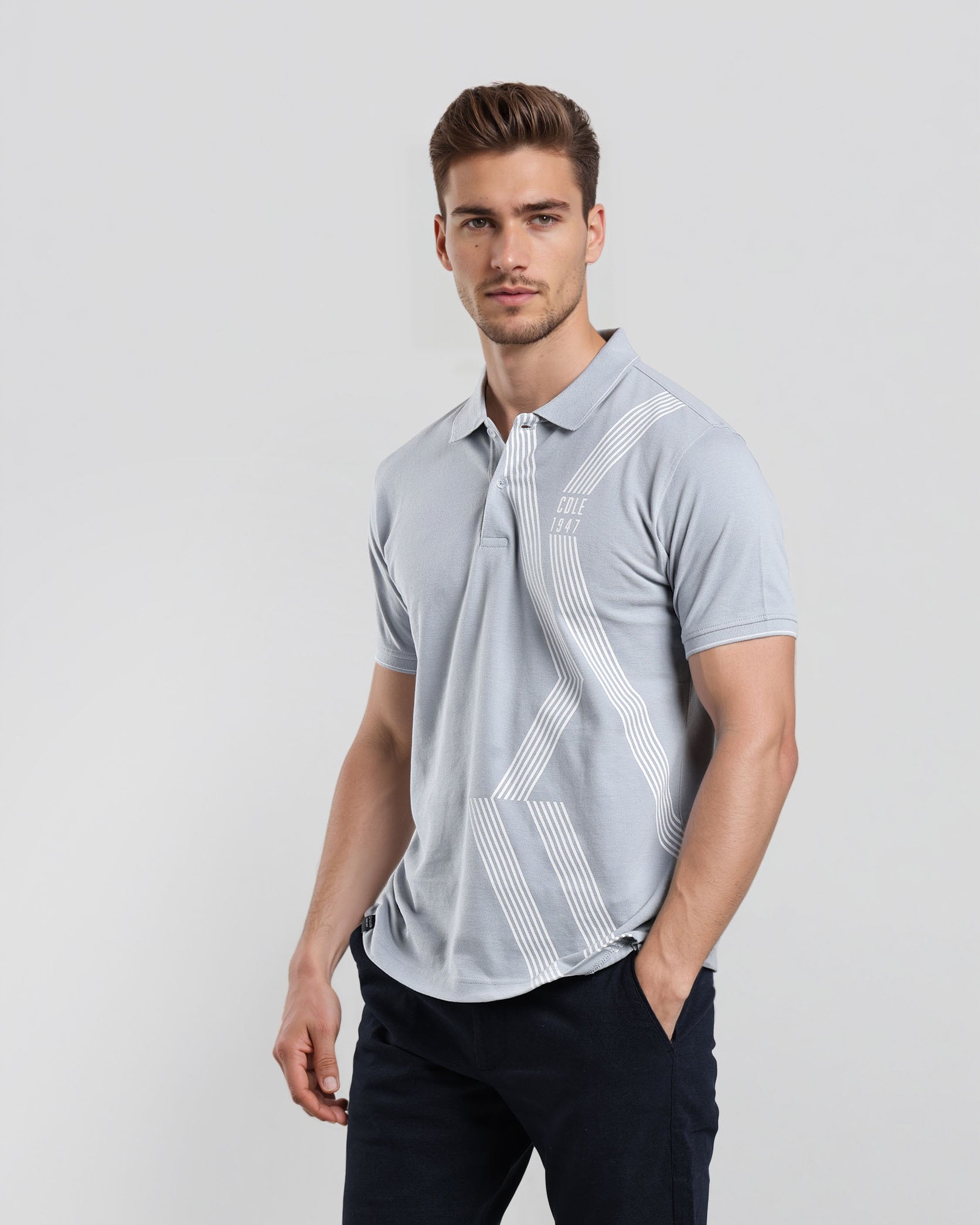 Man wearing a light blue polo shirt with geometric patterns on a white background