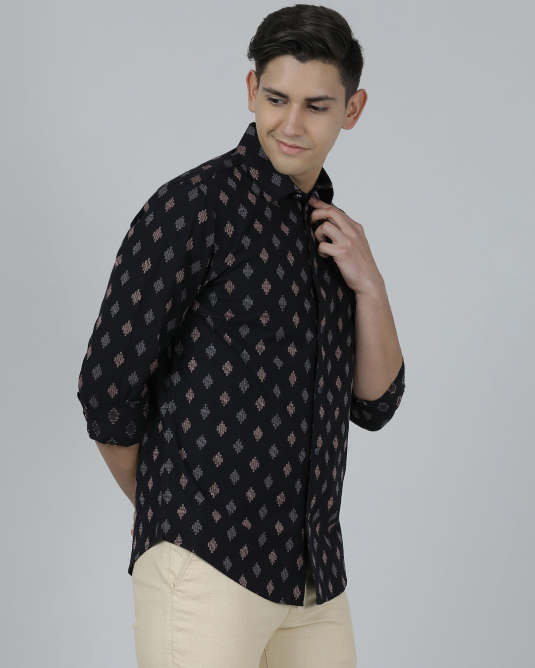 Man wearing a black black printed full sleeve shirt on a light gray background