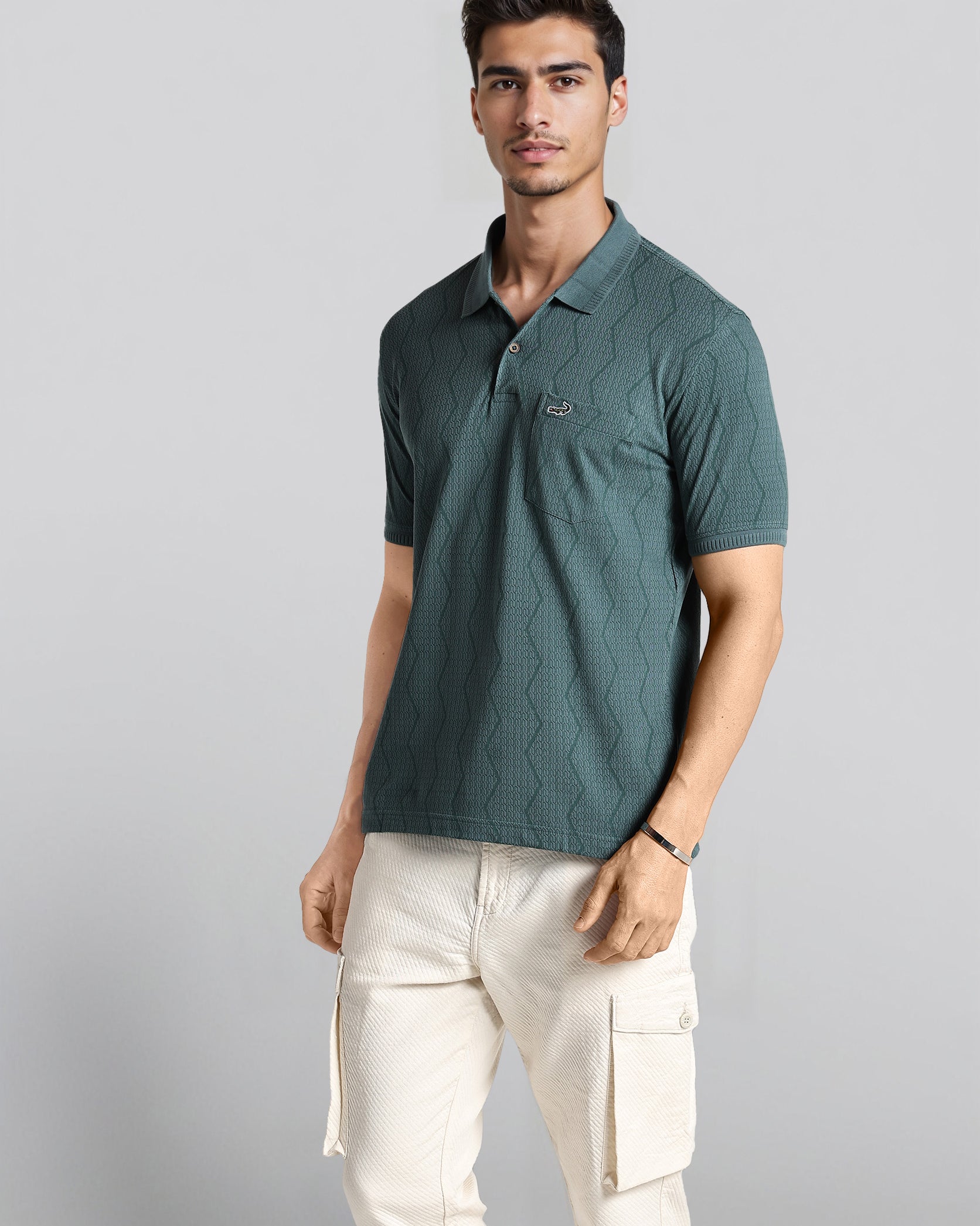 Man wearing a green polo shirt and white pants on a gray background