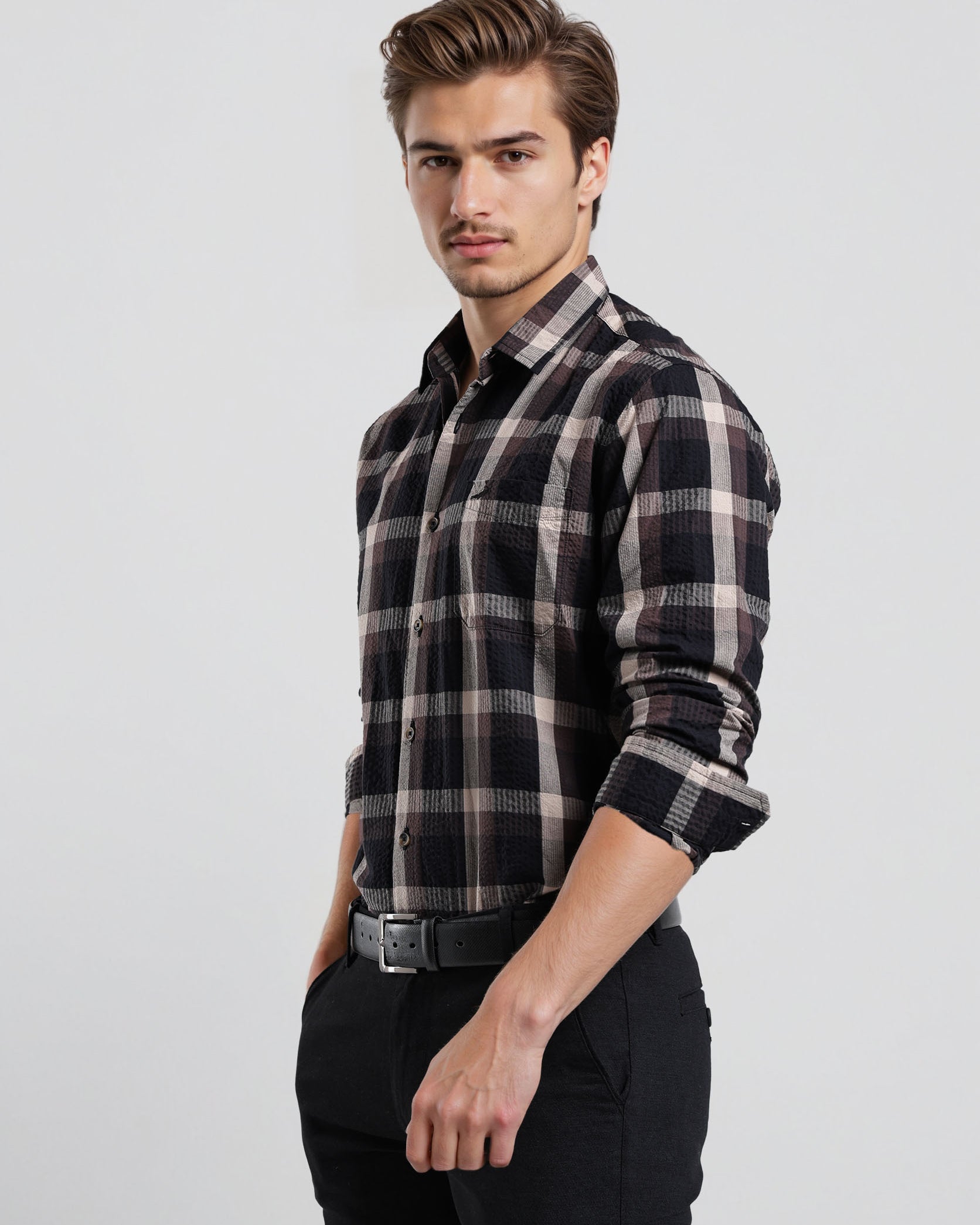 Man wearing a black and white plaid shirt on a light gray background
