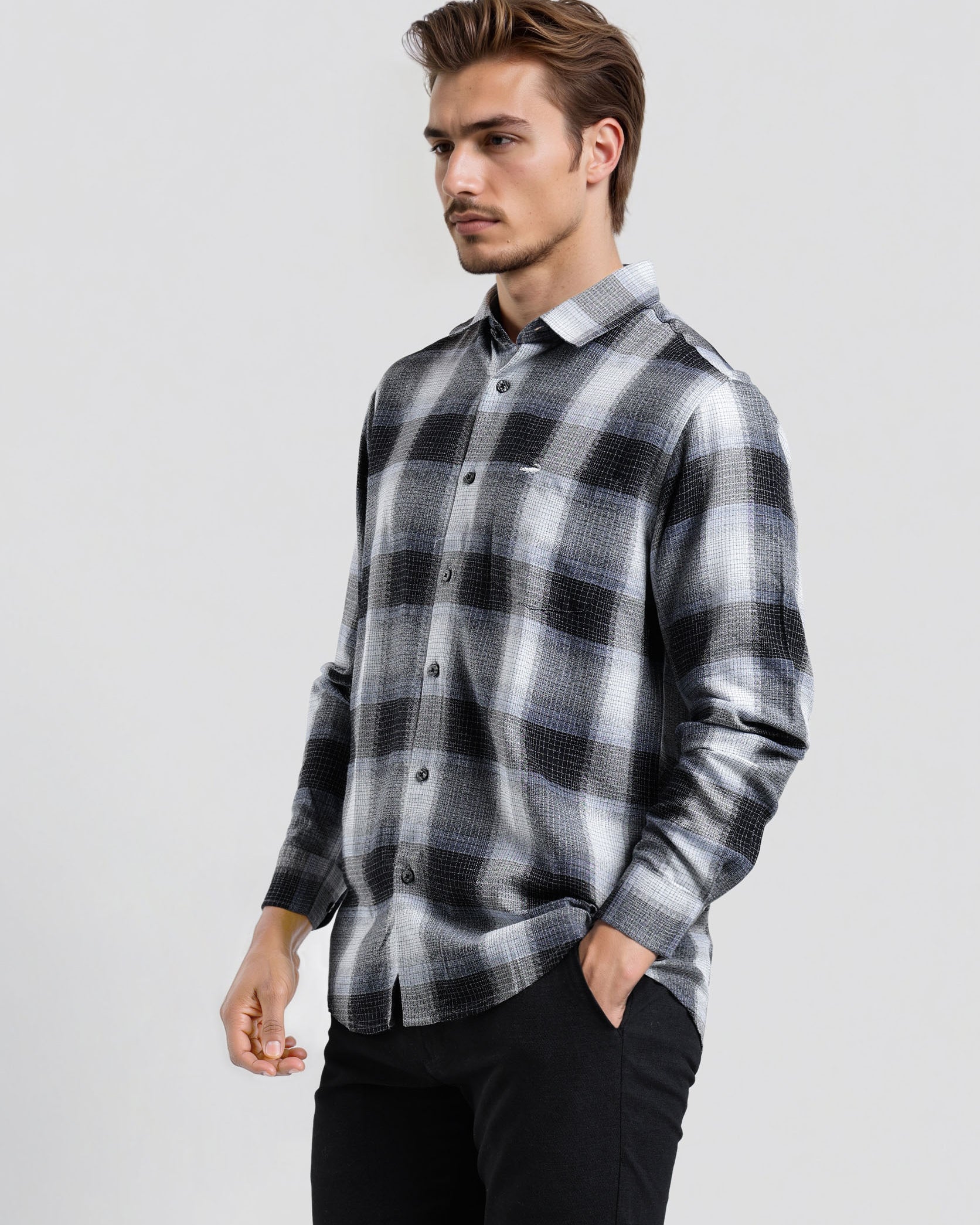 Man wearing a black and gray plaid shirt on a white background