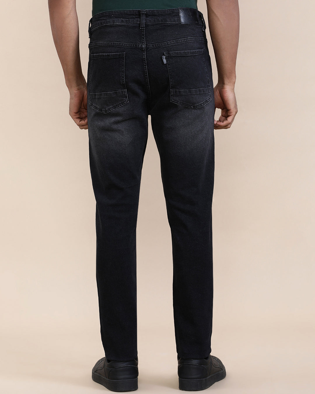 Man wearing a red natural fade wash slim tapered jeans on a light gray background