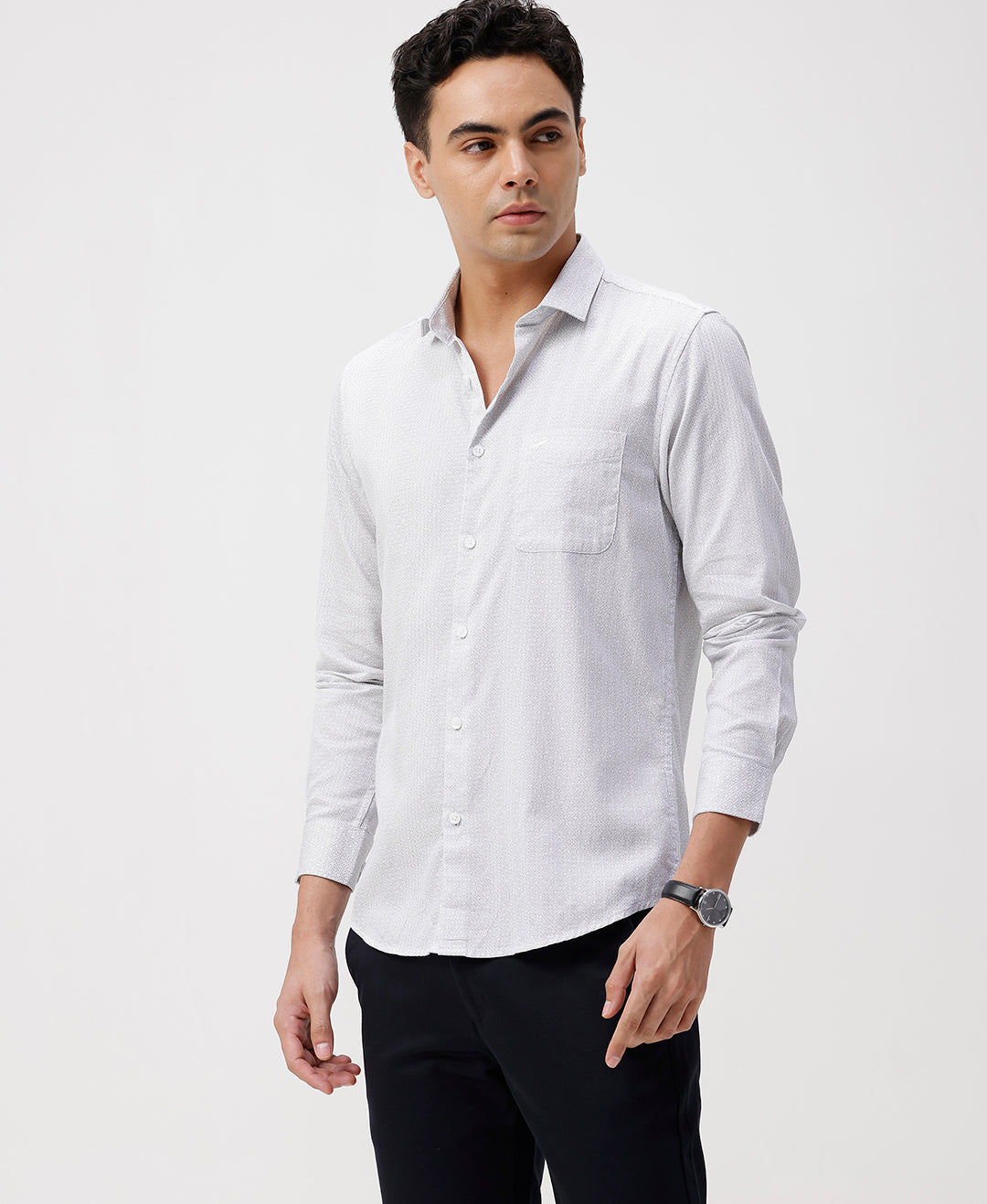 Man wearing a white white all over print slim fit casuals shirts with casual styling on a gray background