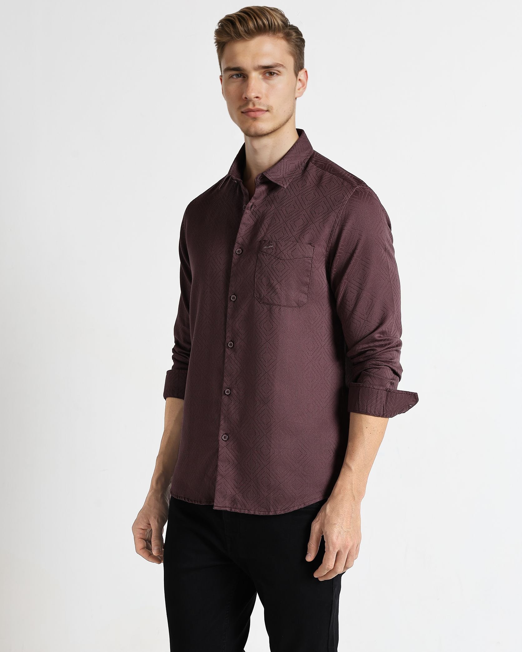 Man wearing a maroon button-up shirt and black pants on a white background