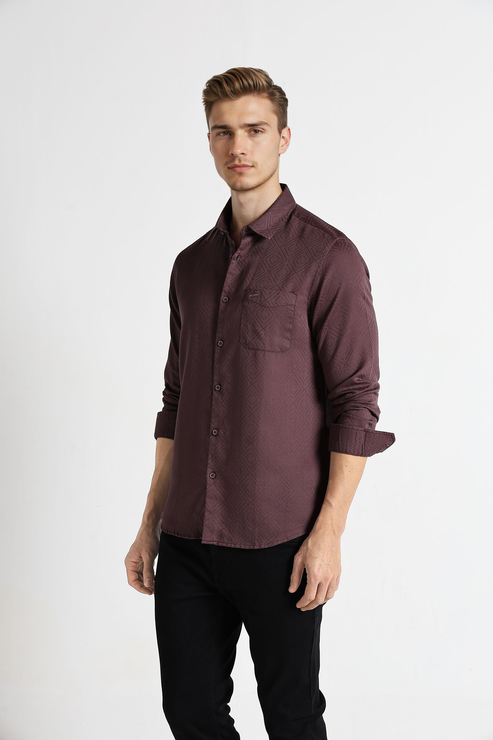 Man wearing a maroon button-up shirt and black pants on a white background