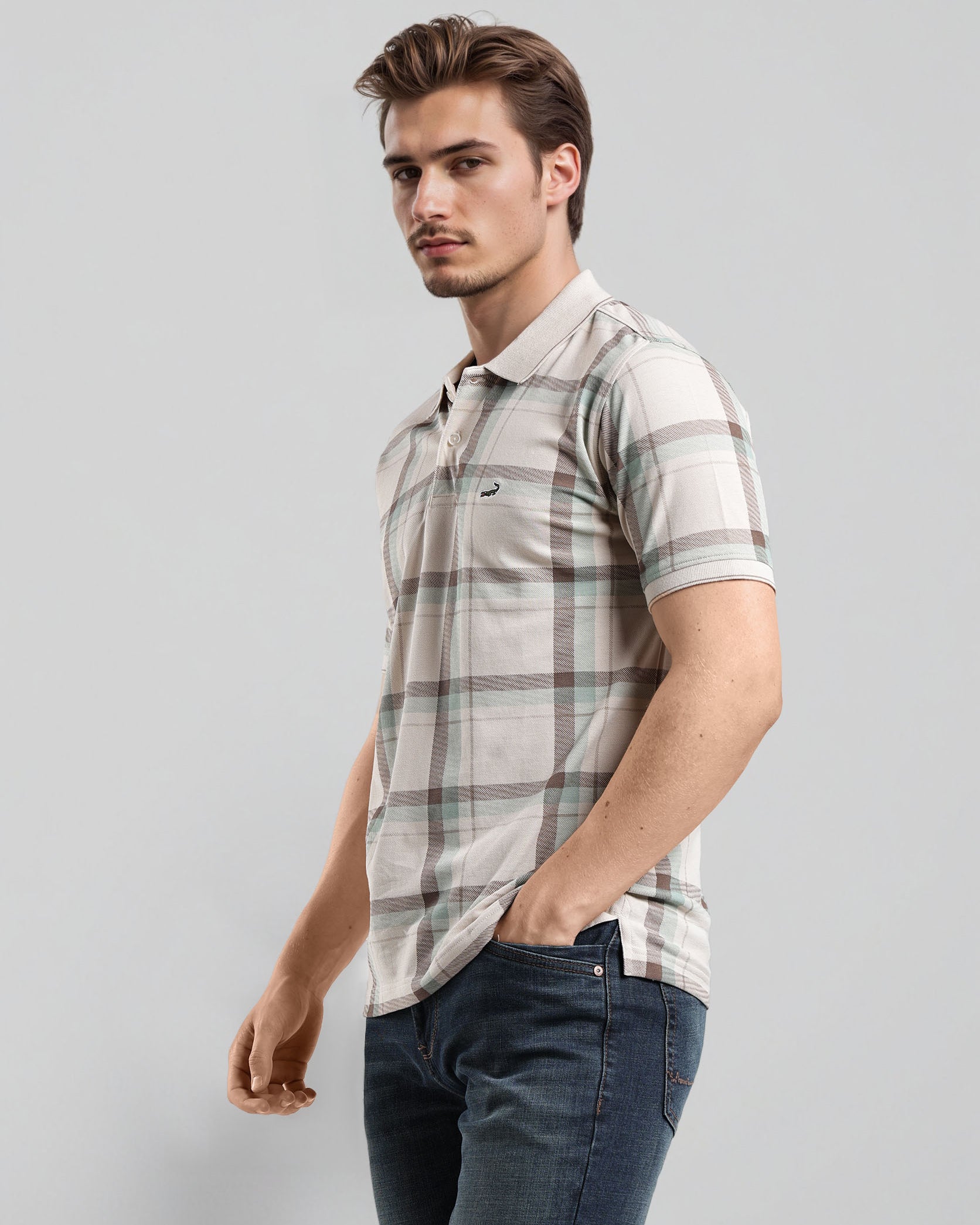 Man wearing a plaid shirt and jeans on a gray background