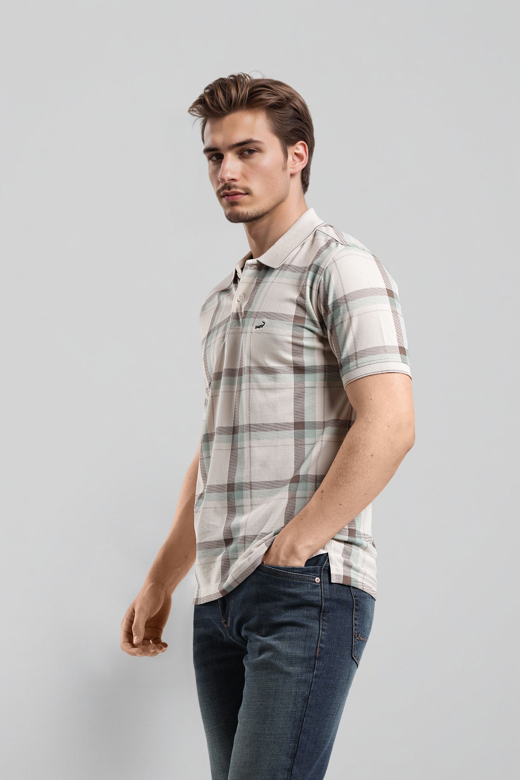 Man wearing a plaid shirt and jeans on a gray background