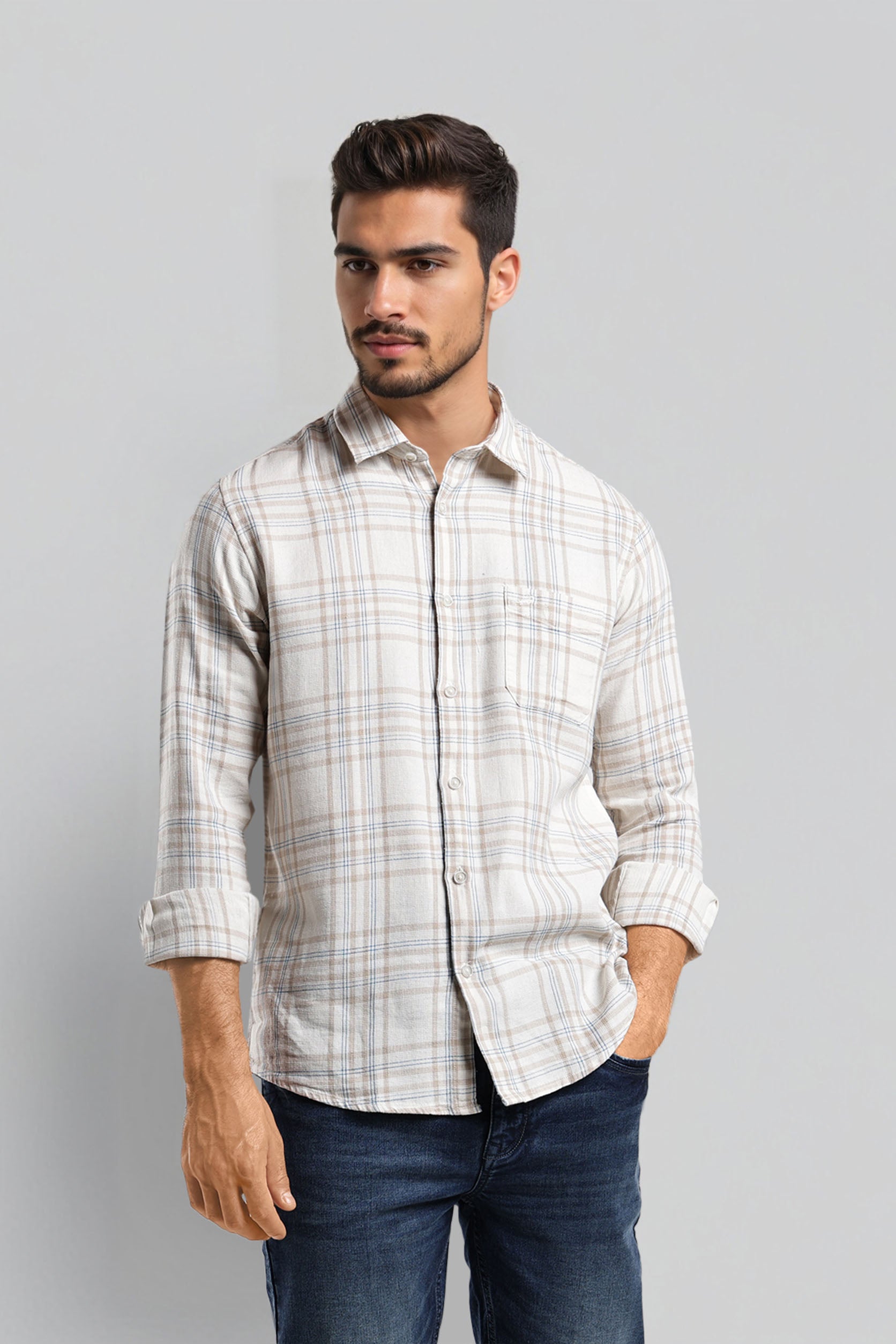 Man wearing a checkered shirt and jeans on a gray background