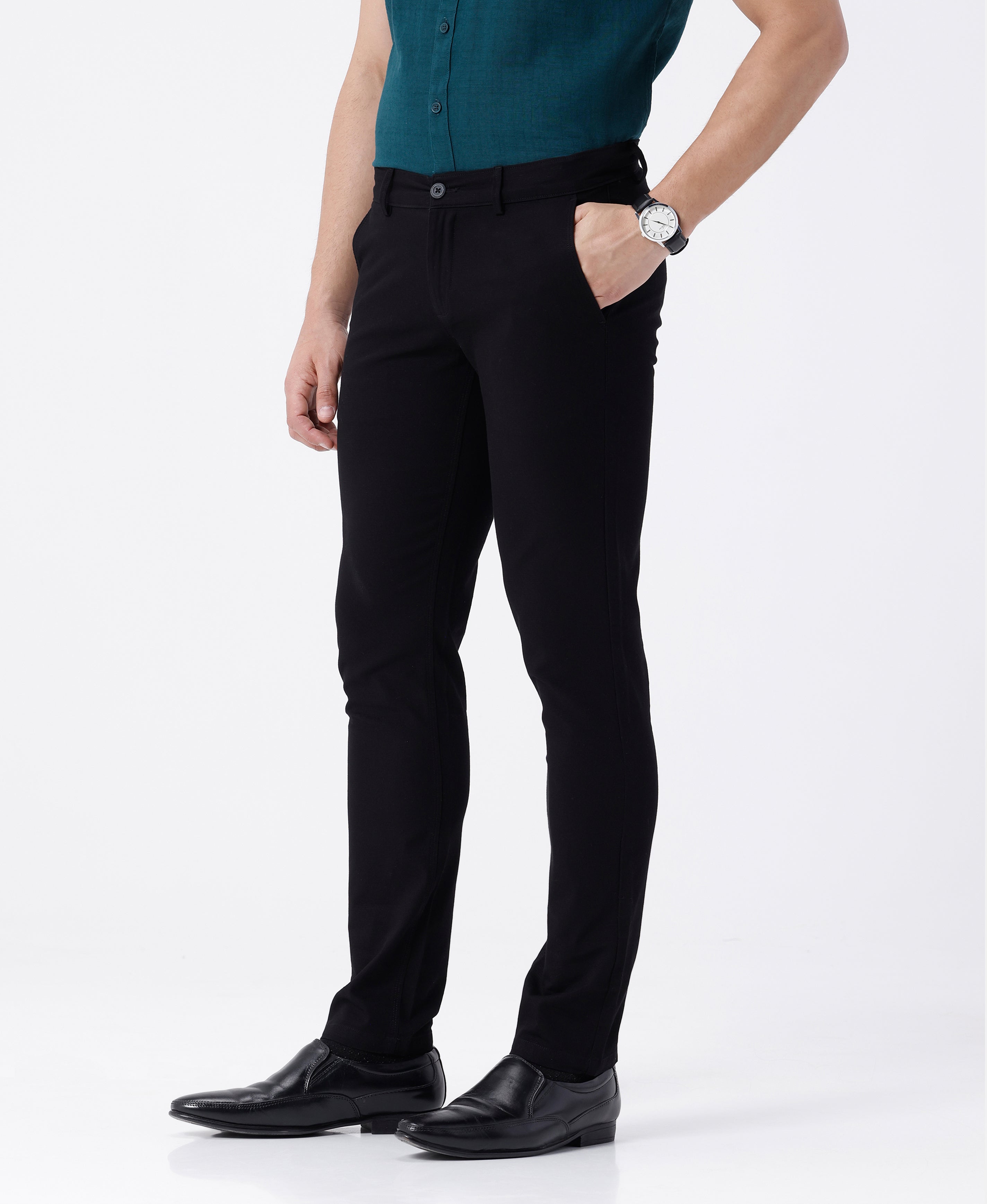 Woman wearing a black textured essential chinos in black on a light gray background
