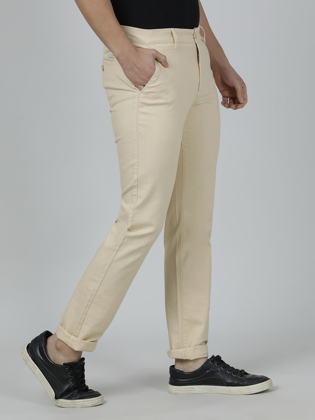 Man wearing a beige solid slim fit casual trouser beige with casual styling on a gray background