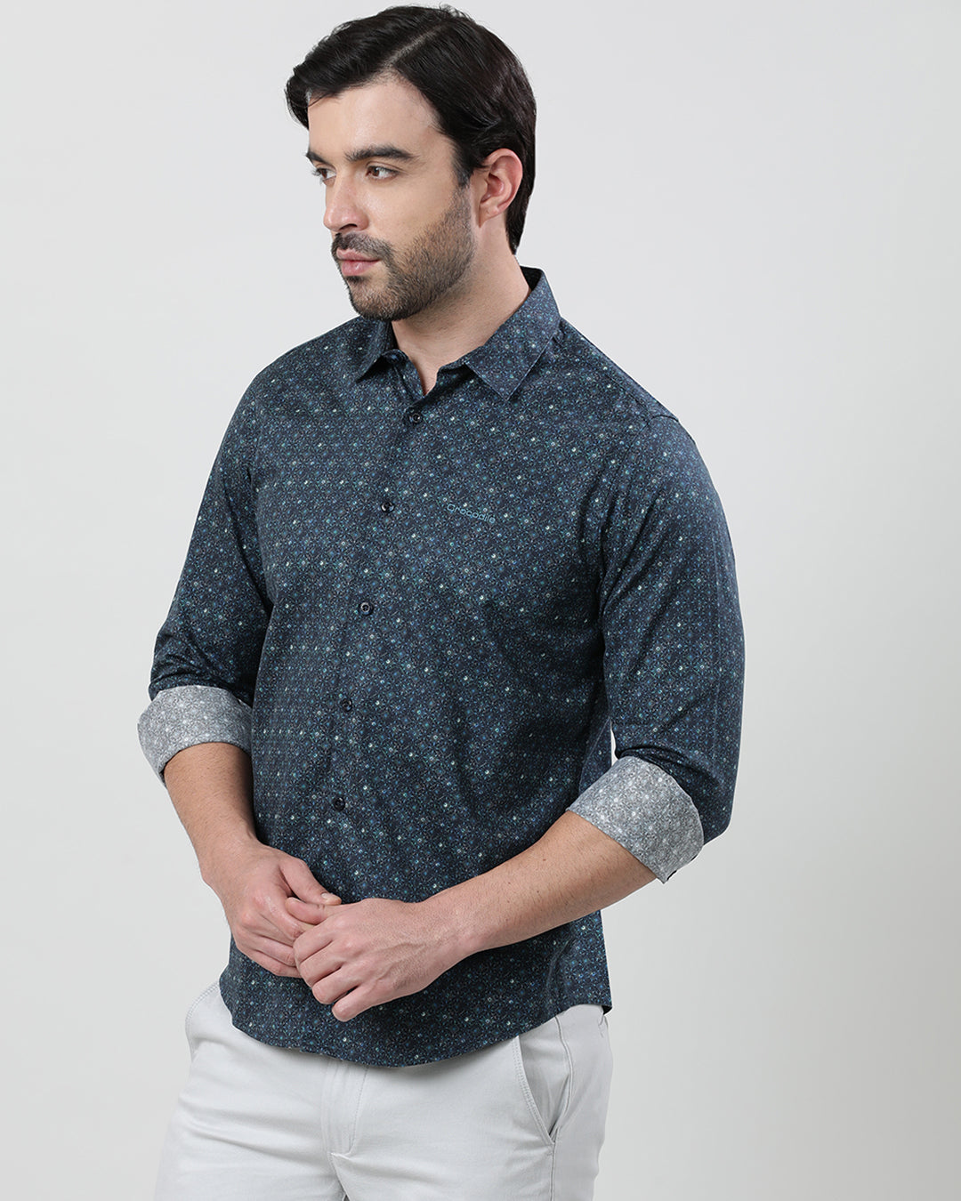 Man wearing a blue dark blue printed full sleeve 100% cotton shirt with casual styling on a gray background