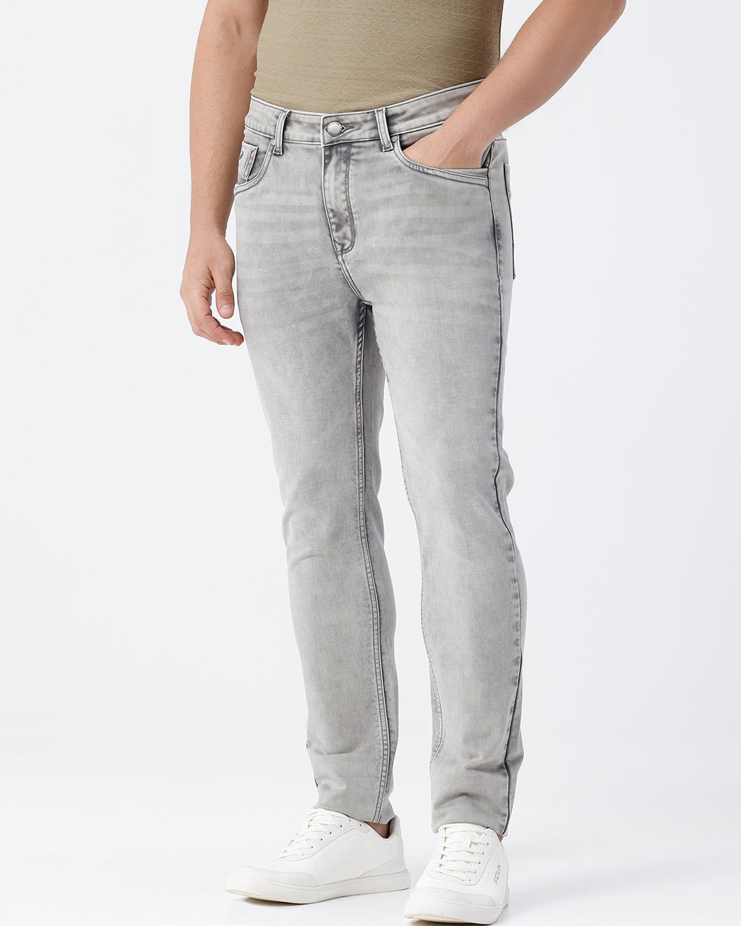 Man wearing a grey light grey knit slim fit jeans on a light gray background