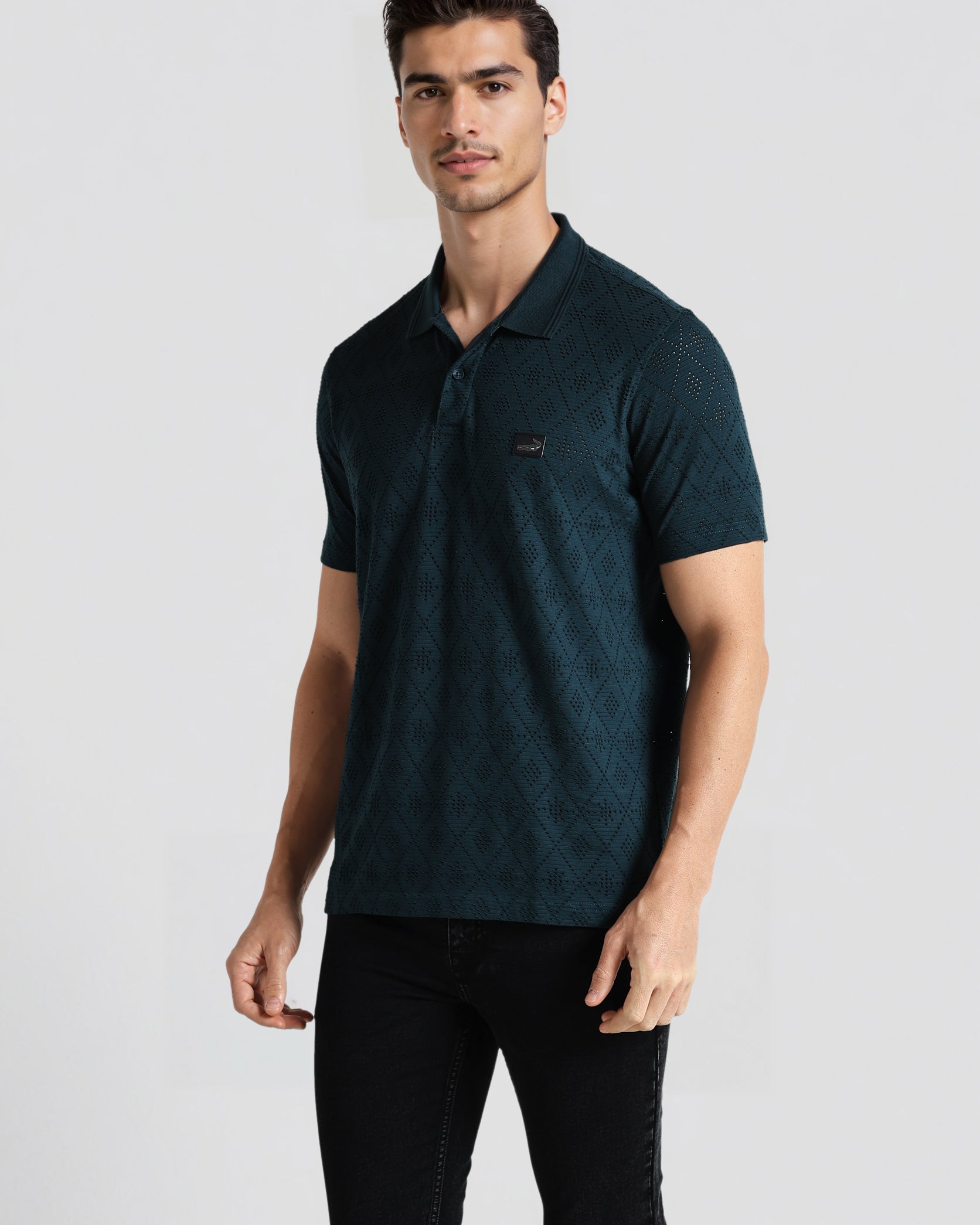 Man wearing a dark green polo shirt on a light gray background