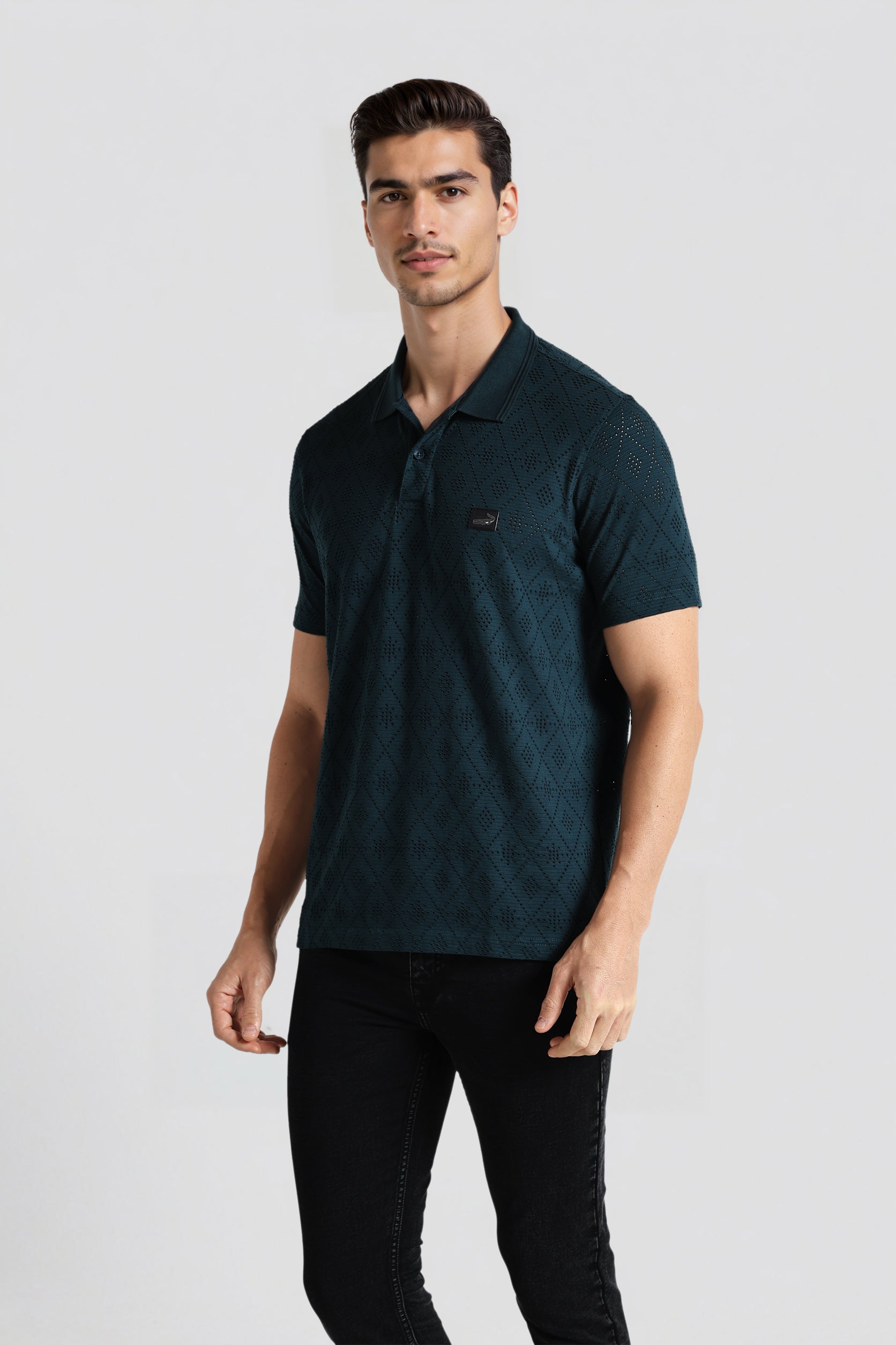 Man wearing a dark green polo shirt on a light gray background