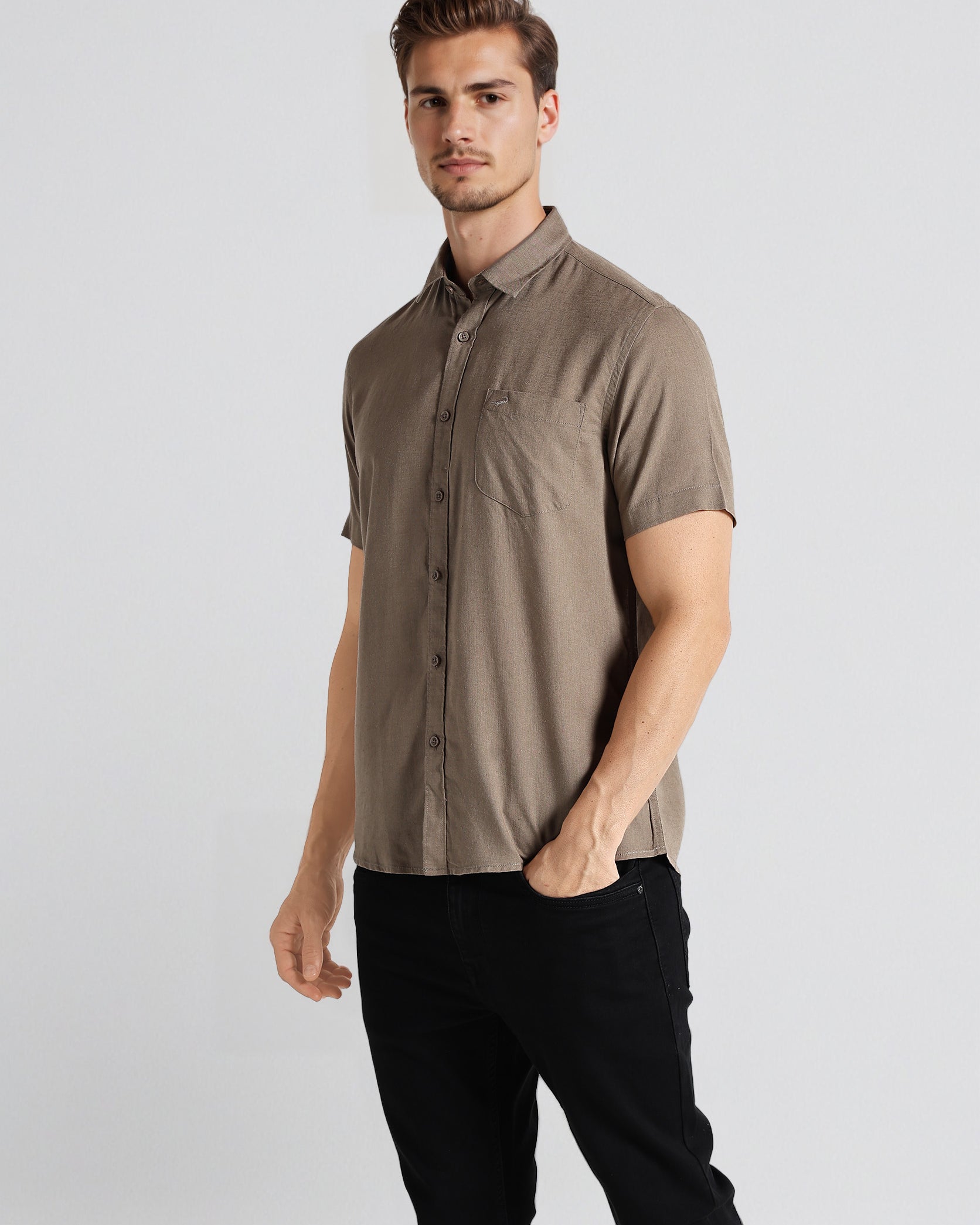 Man wearing a brown short-sleeve shirt and black pants on a white background