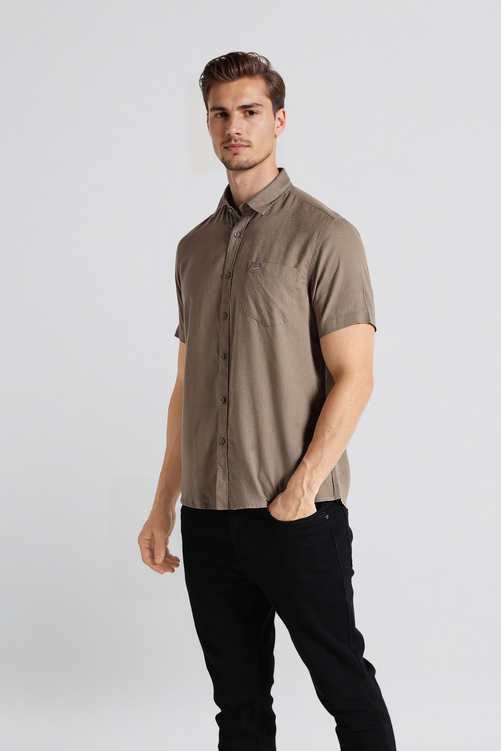 Man wearing a brown short-sleeve shirt and black pants on a white background