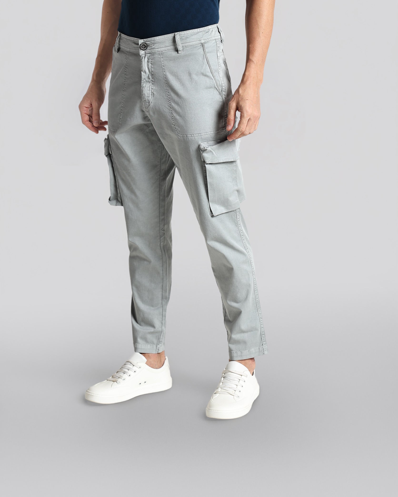 Person wearing gray cargo pants on a light gray background
