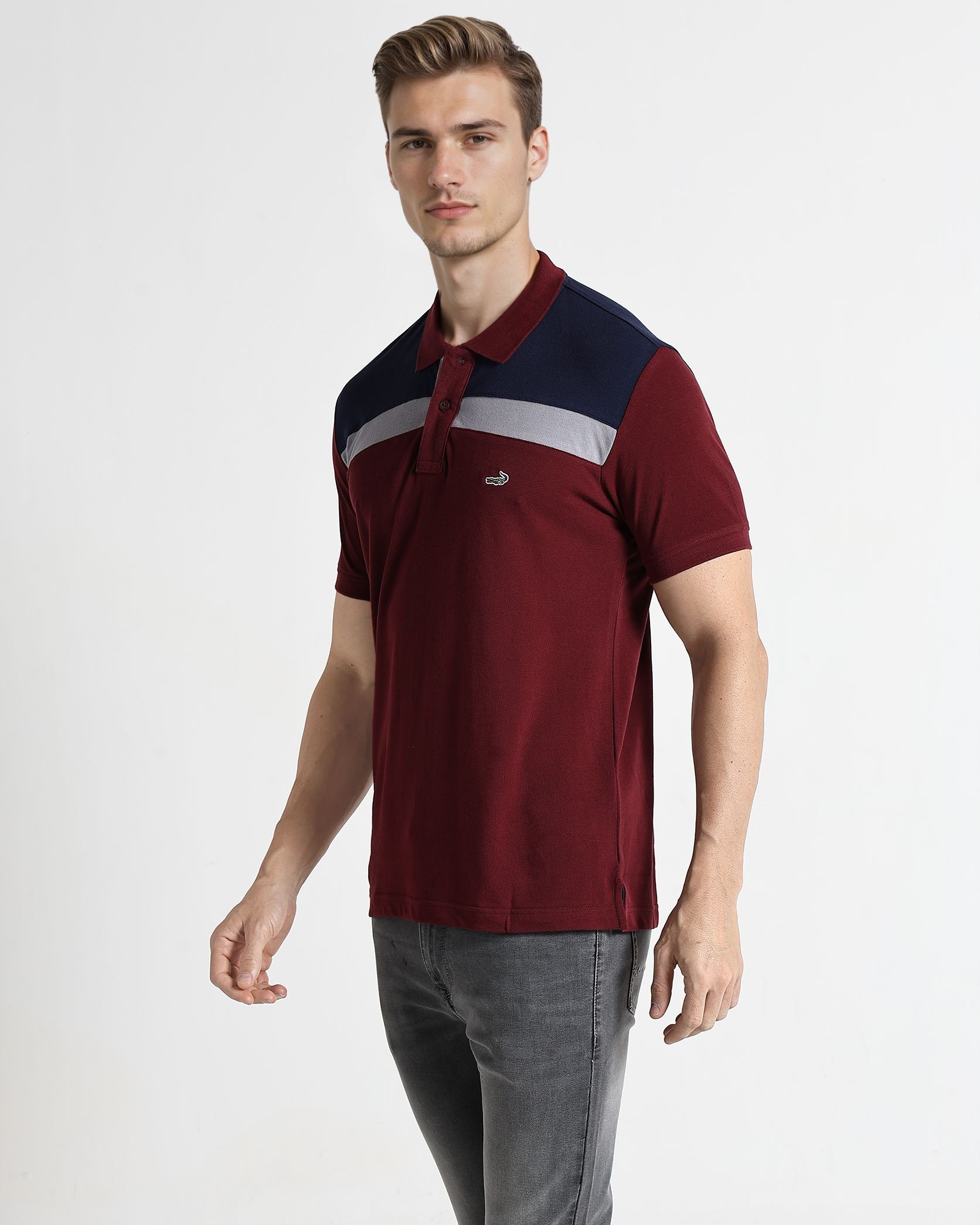 Man wearing a maroon and navy polo shirt with a logo on a white background