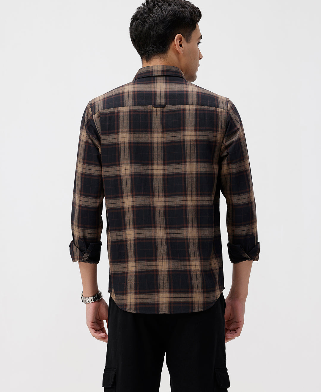 Man wearing a brown oxford checks shirt brown with casual styling on a gray background