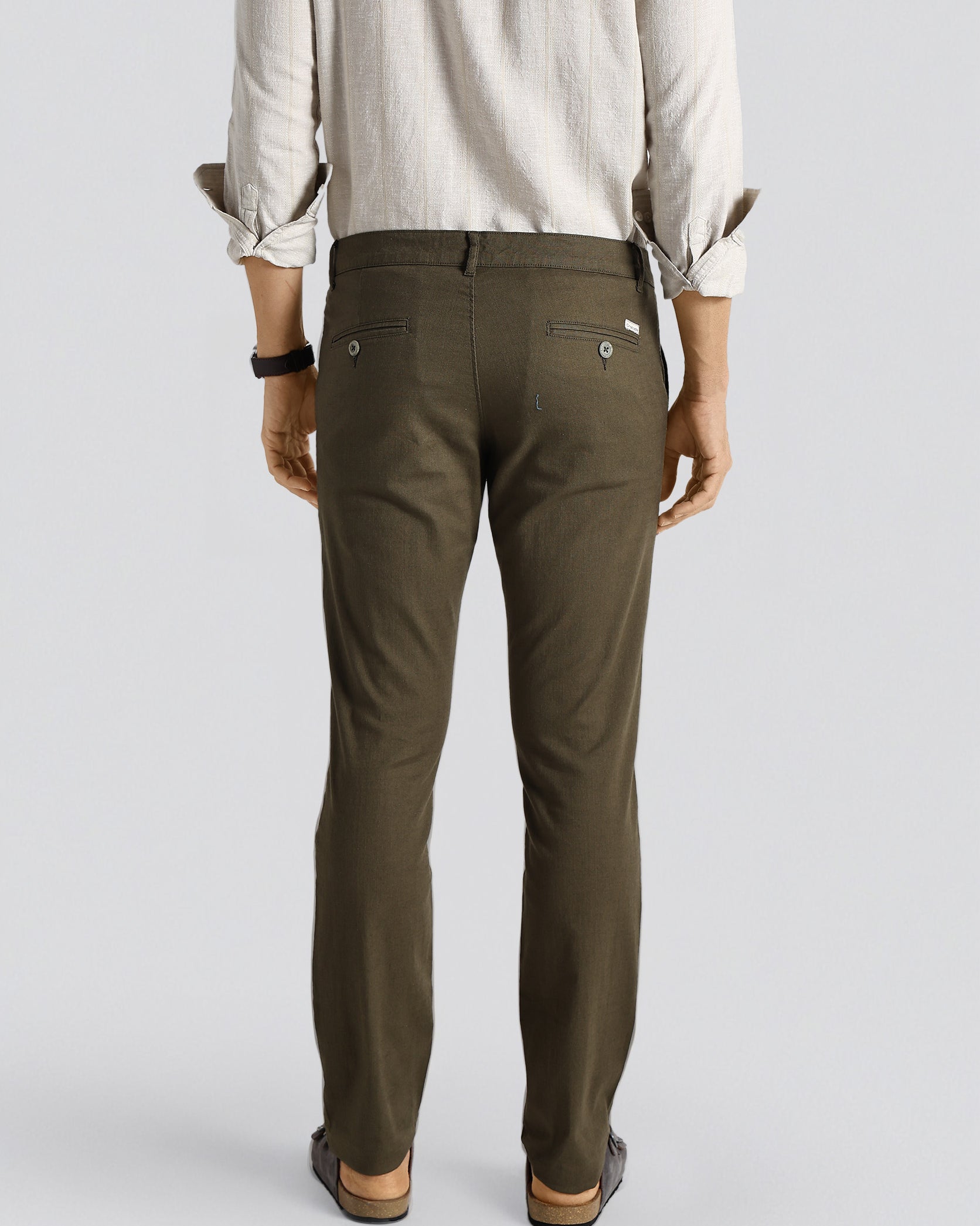 Person wearing olive green pants on a plain background