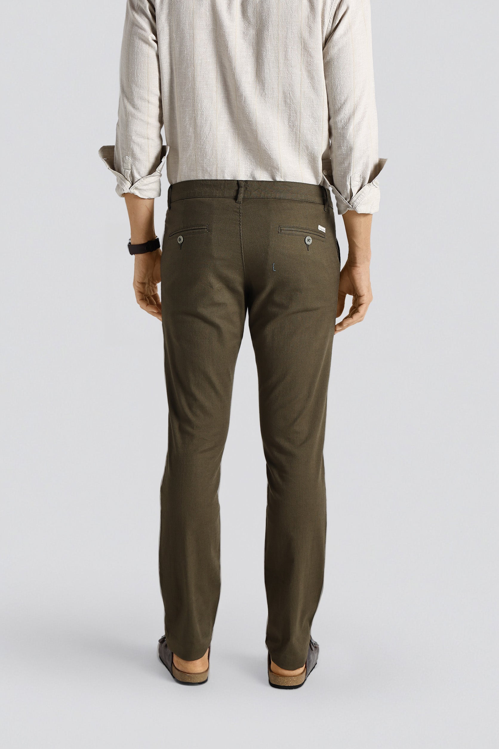 Person wearing olive green pants on a plain background