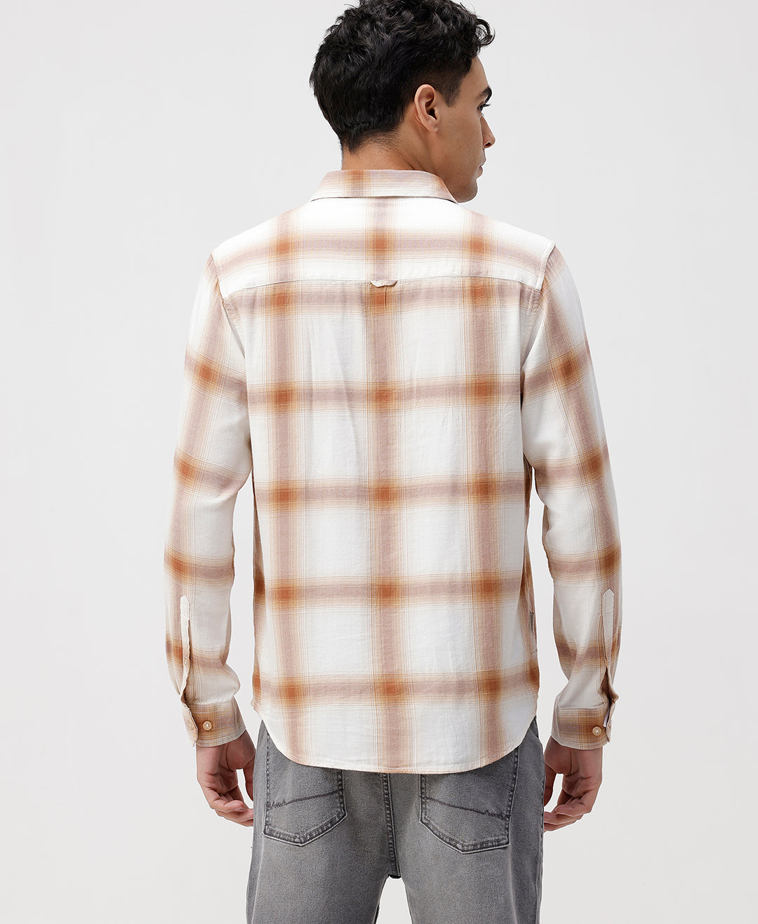 Man wearing a red textured grunge print shirt with casual styling on a gray background