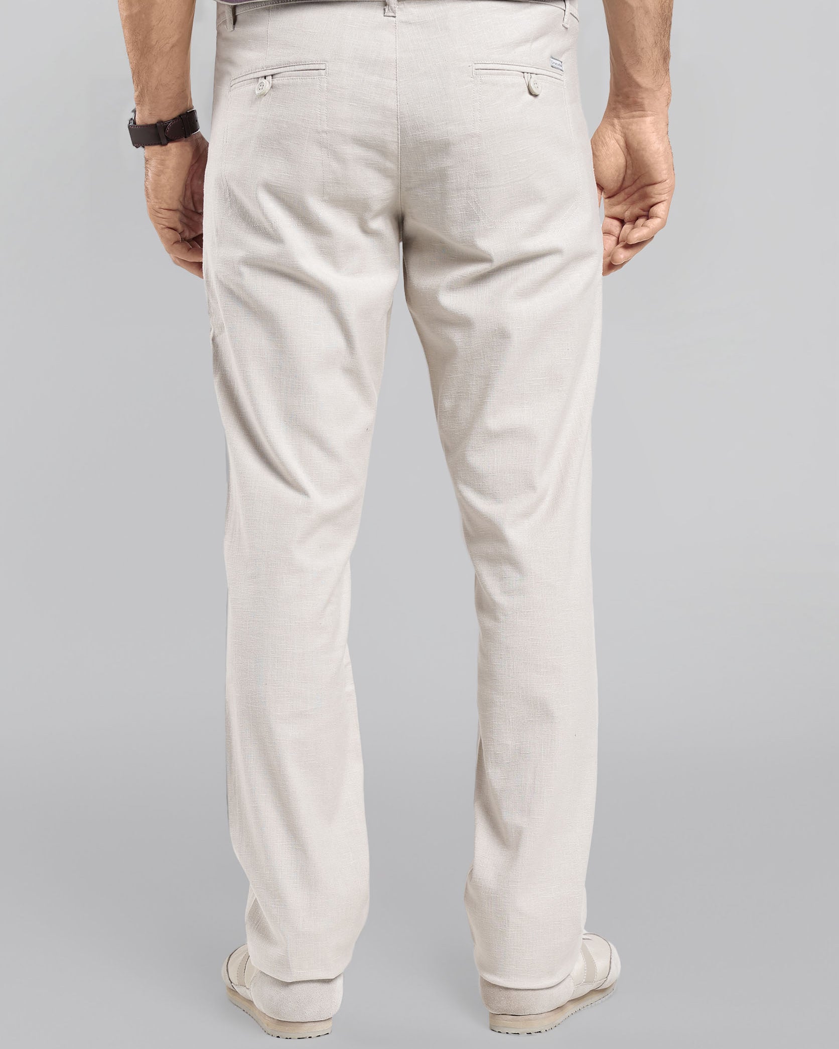 Person wearing light-colored pants on a gray background