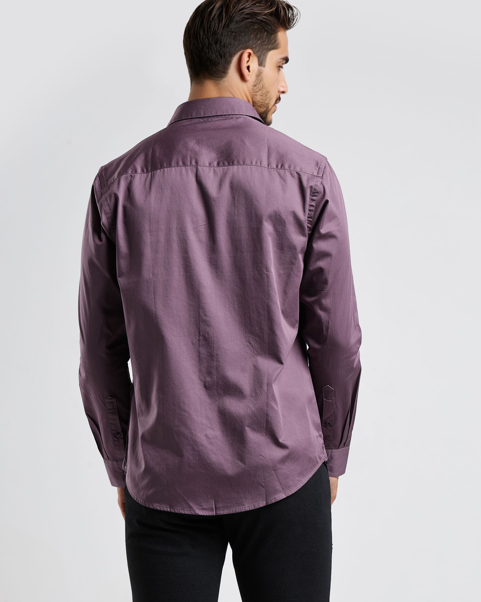 Man wearing a purple shirt from behind on a white background