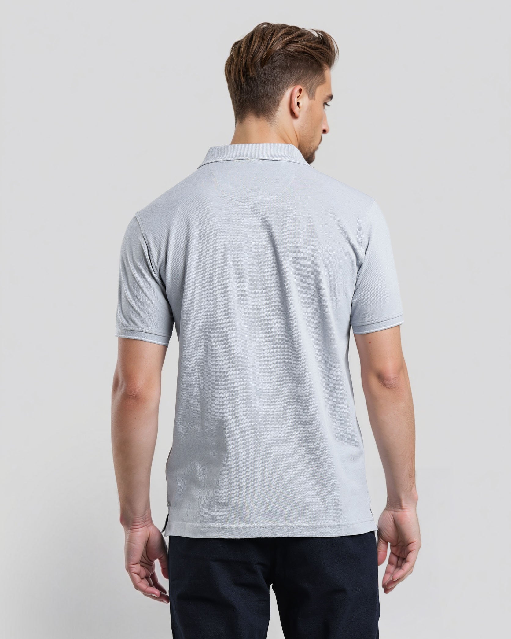 Man wearing a light gray polo shirt on a plain background