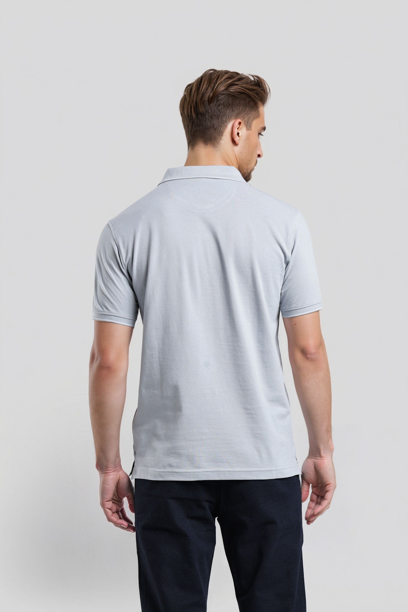 Man wearing a light gray polo shirt on a plain background