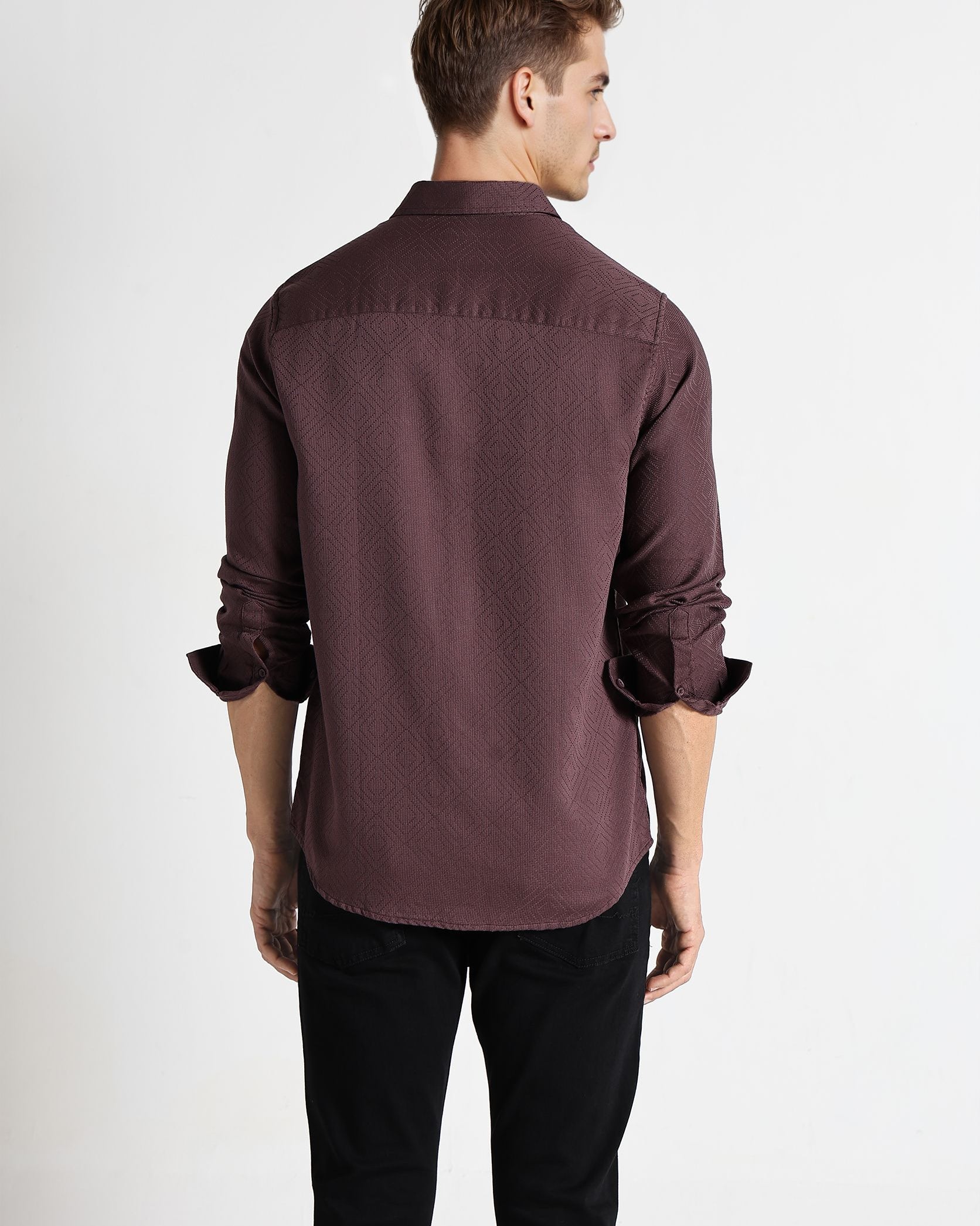 Man wearing a brown shirt with rolled-up sleeves on a white background