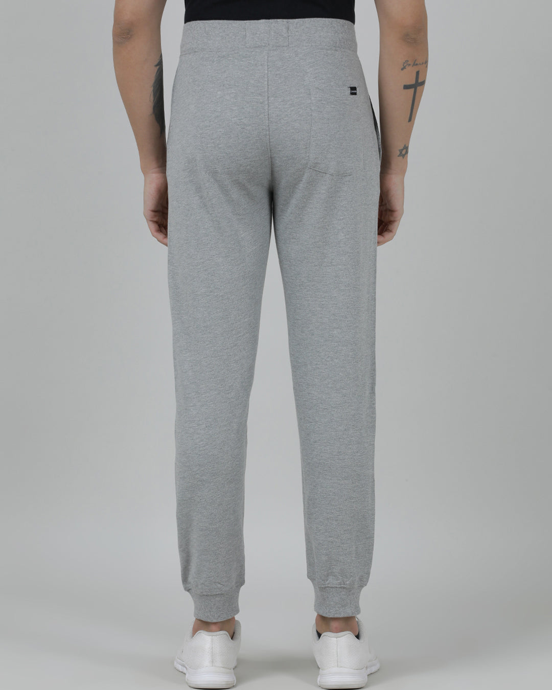 Person wearing gray sweatpants on a plain background