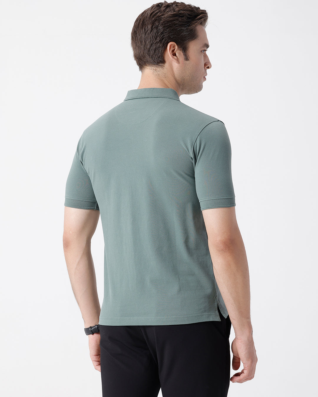 Man wearing a green iceberg green chest print slim fit polo t shirt on a light gray background