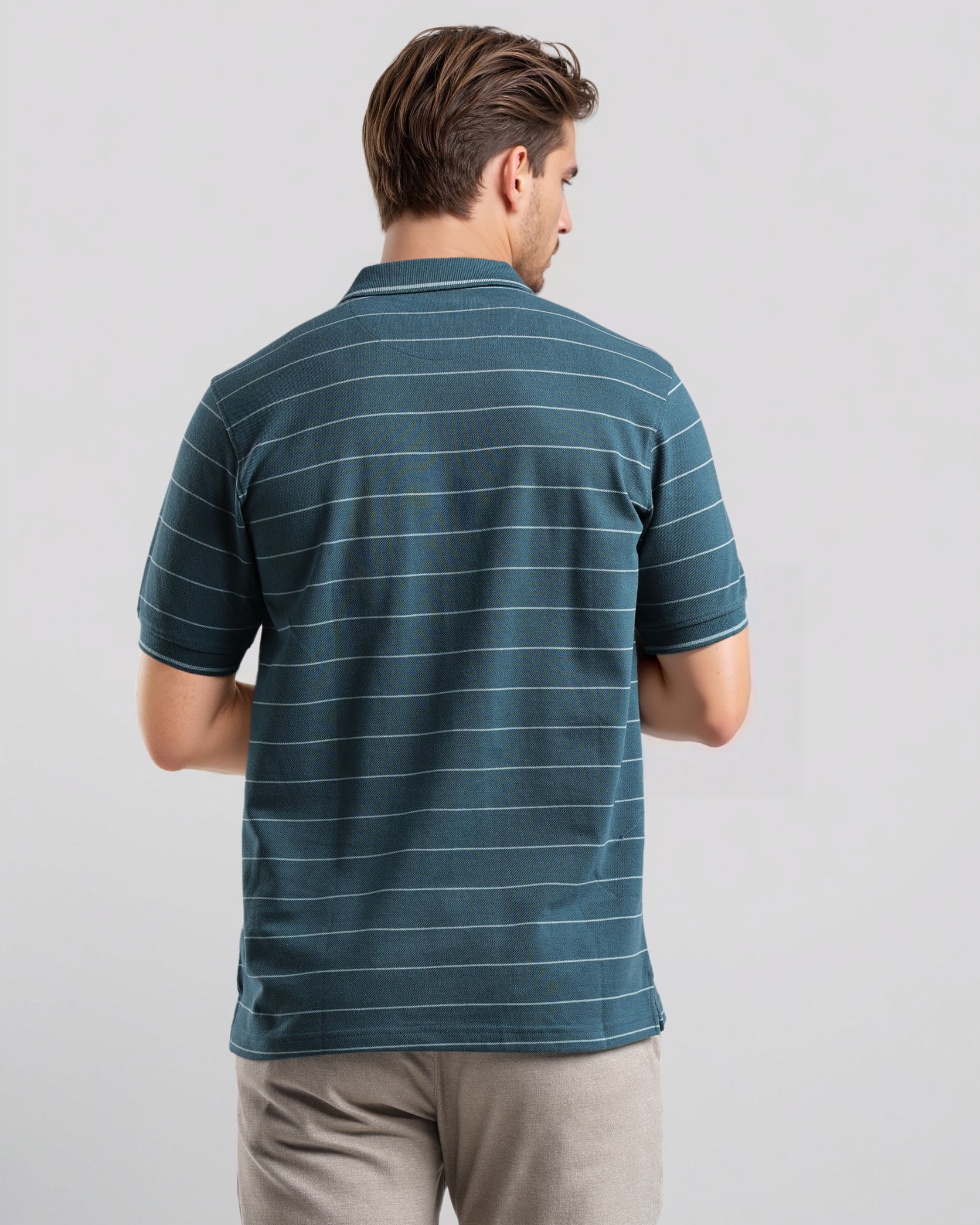 Man wearing a blue striped polo shirt against a light gray background