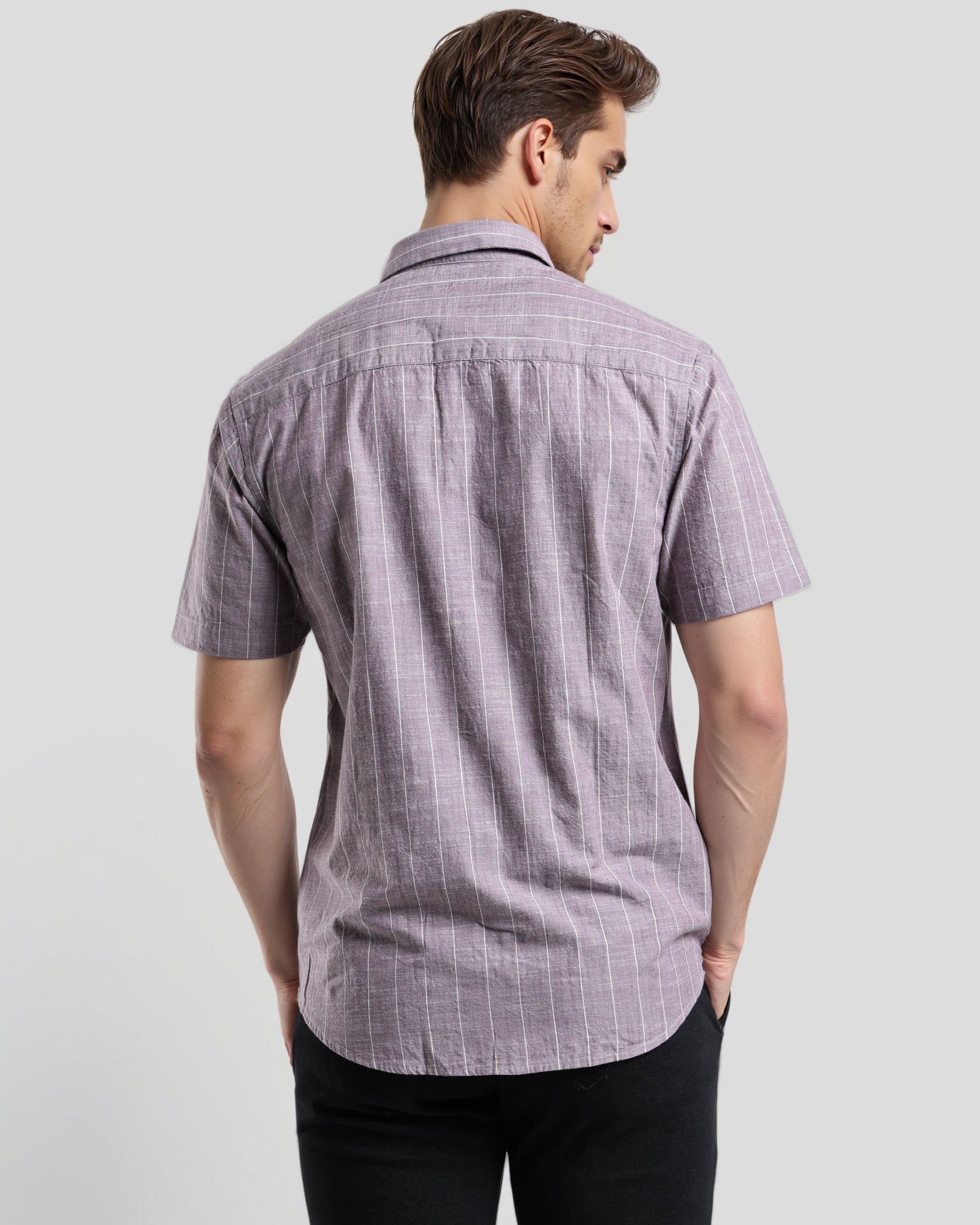 Man wearing a short-sleeve checkered shirt against a plain background