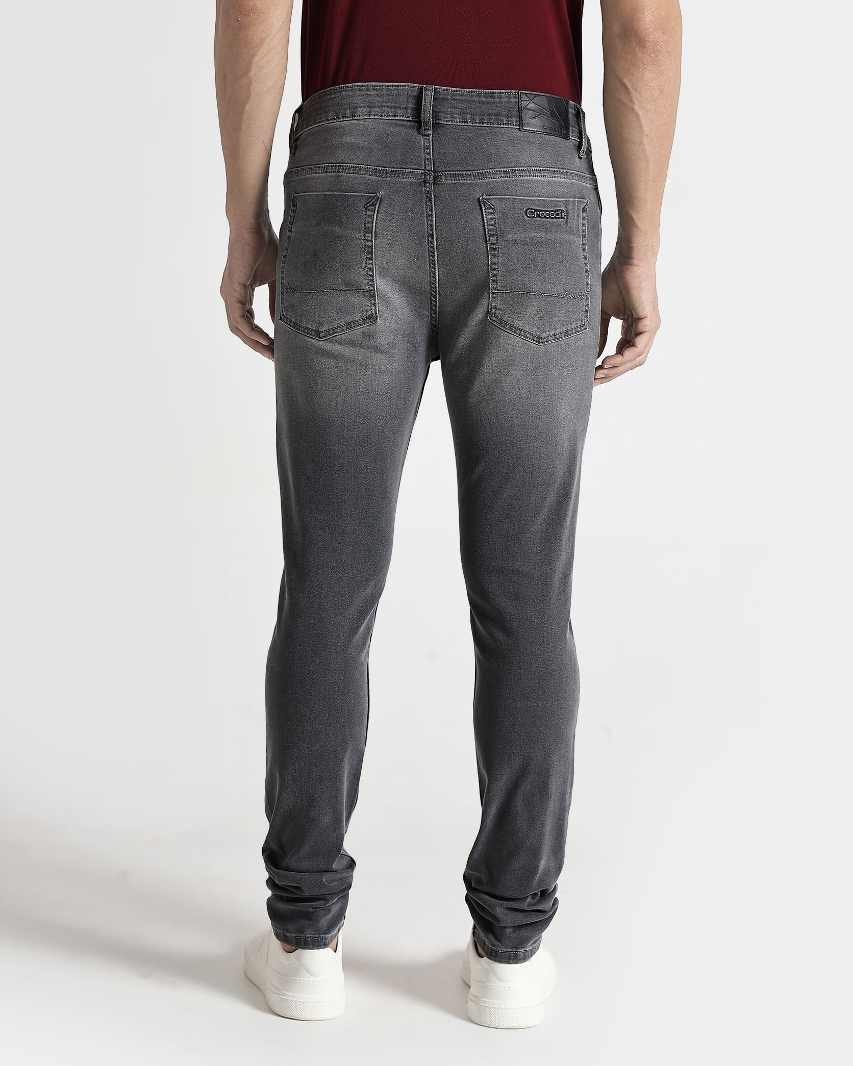 Person wearing gray jeans on a white background