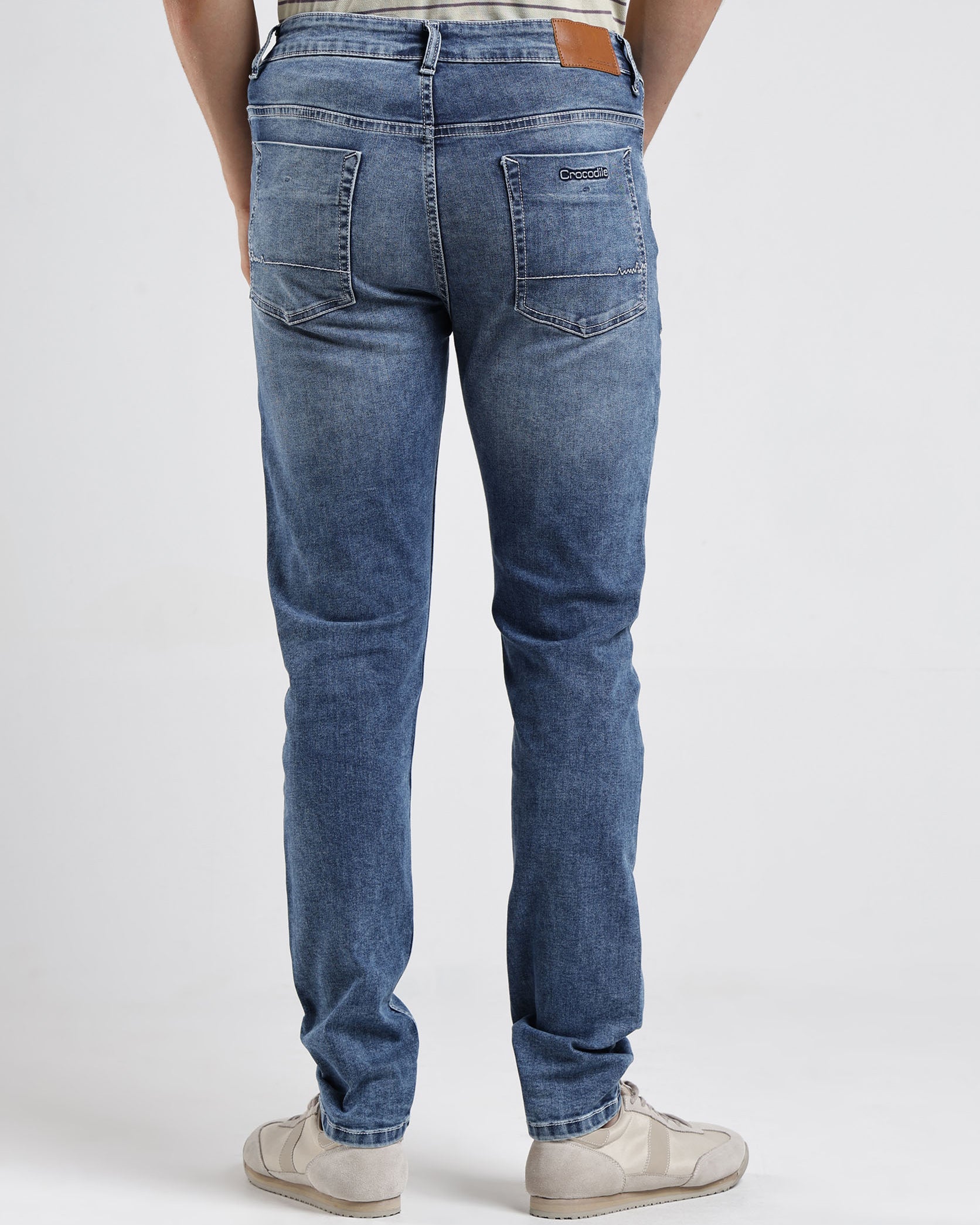 Person wearing blue jeans on a white background