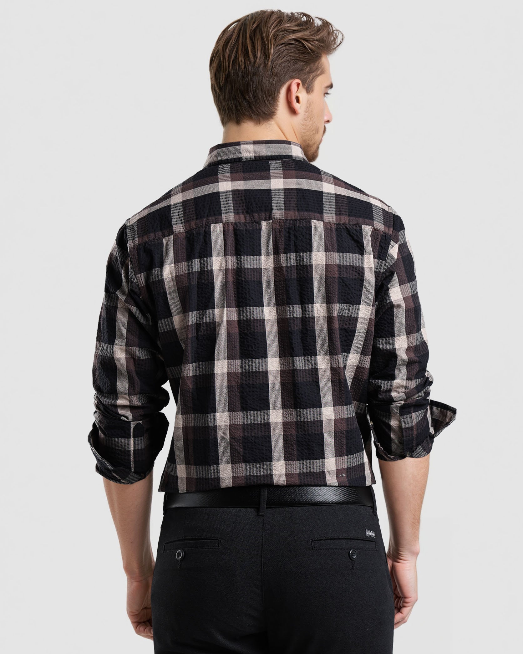 Man wearing a black and white plaid shirt on a light gray background