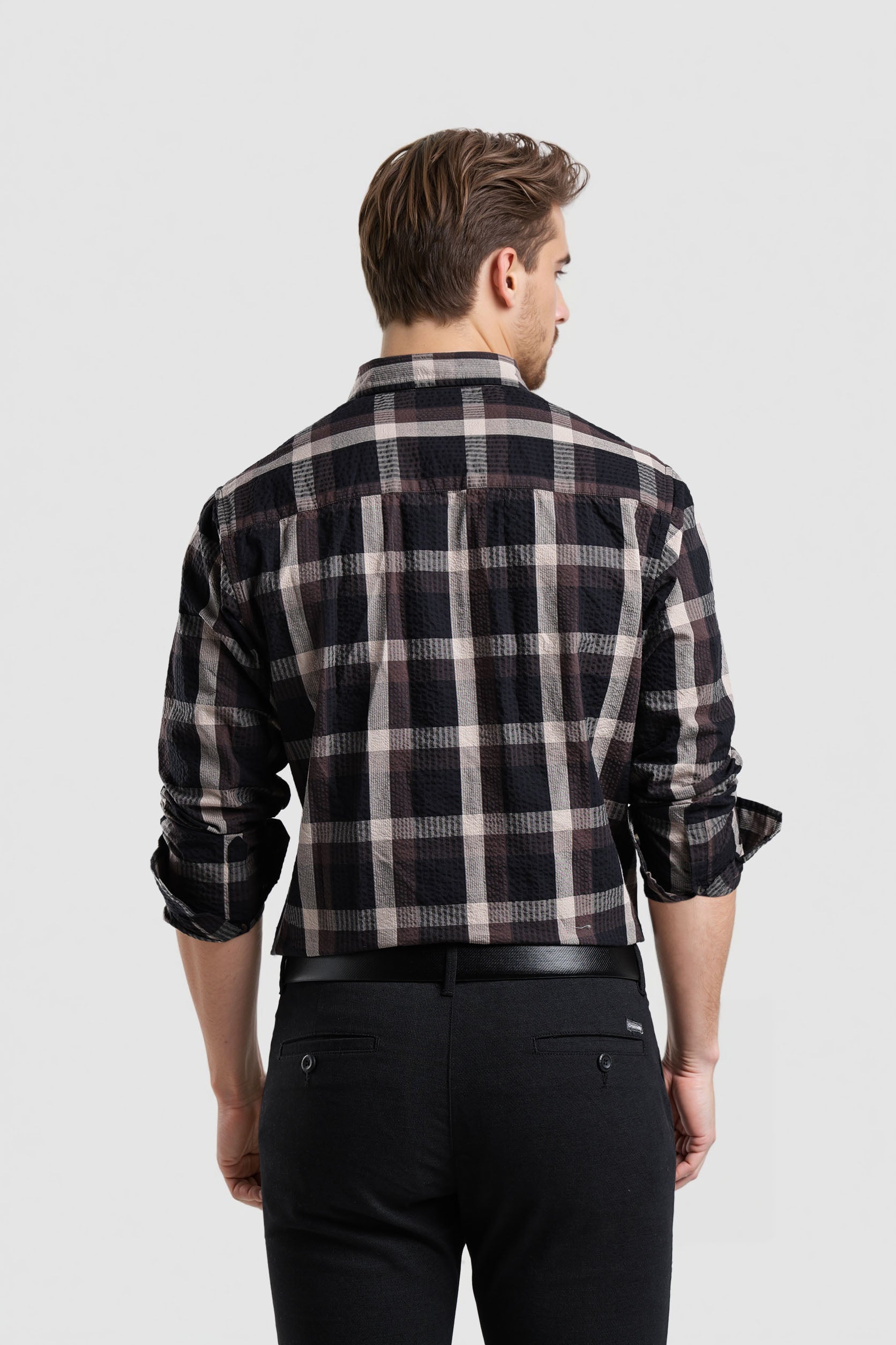 Man wearing a black and white plaid shirt on a light gray background