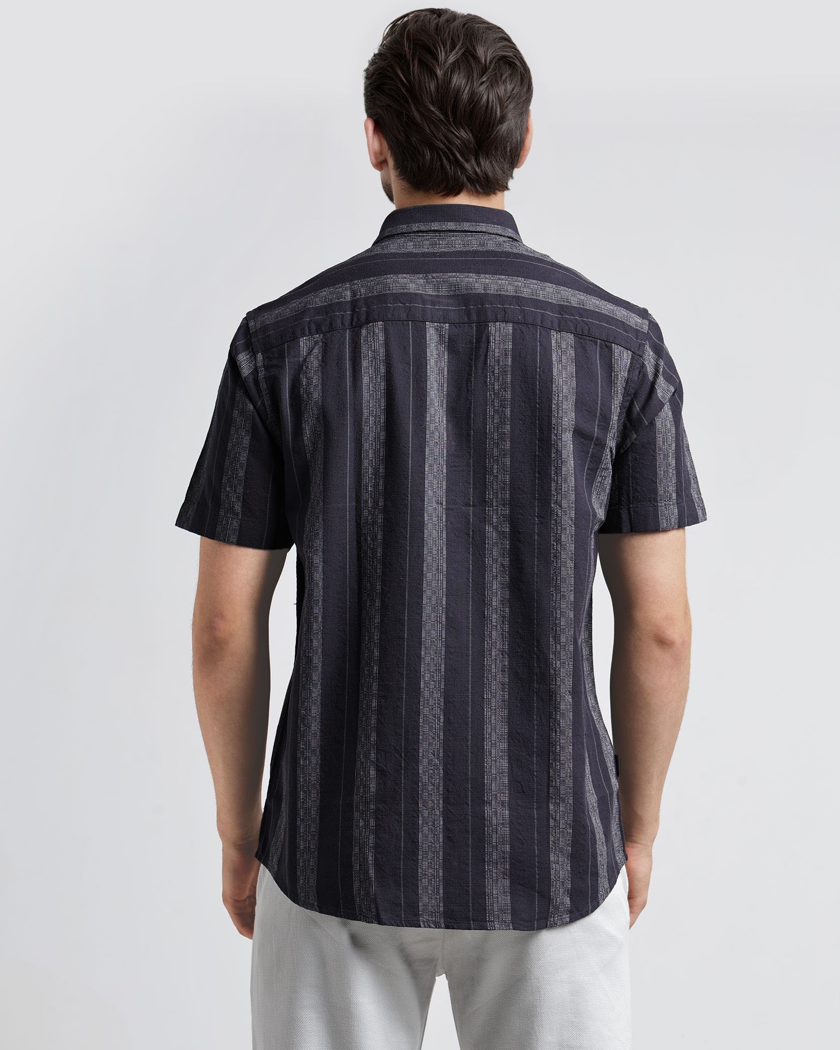 Man wearing a black and gray striped shirt on a white background