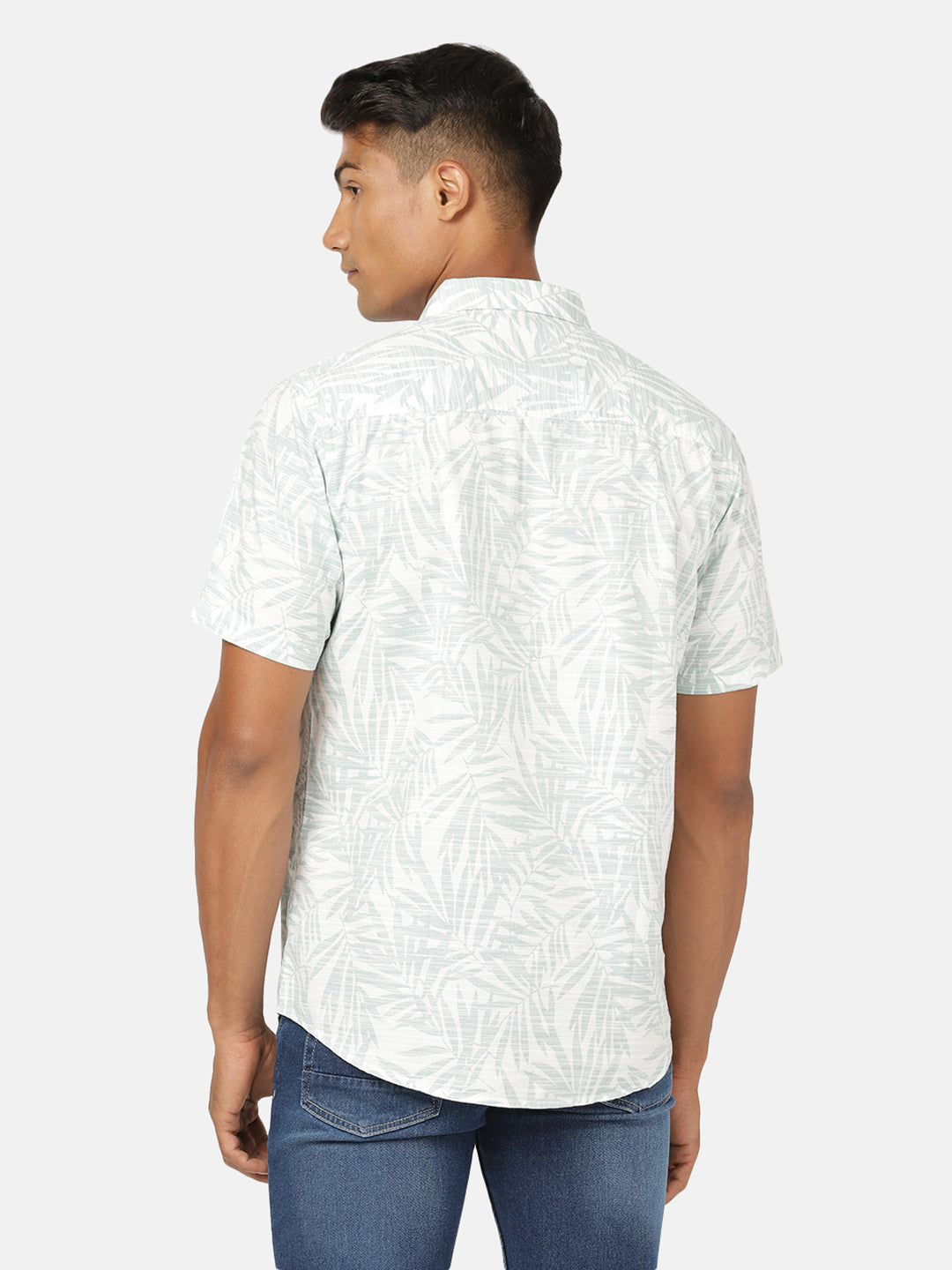 Man wearing a green sea green printed half sleeve 100% cotton shirt on a light gray background