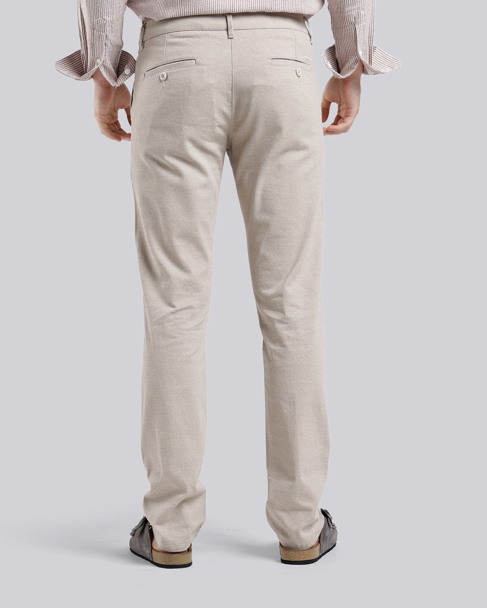 Person wearing beige pants on a plain background