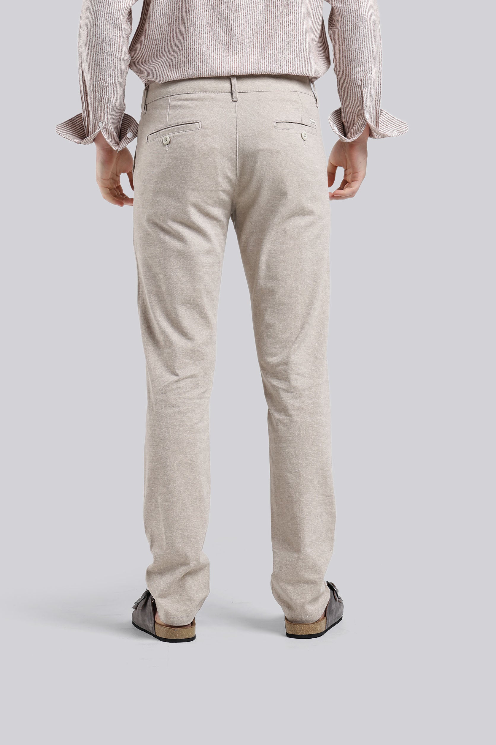 Person wearing beige pants on a plain background